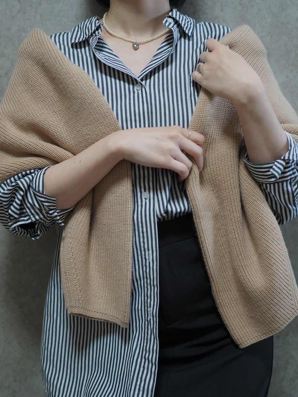 ブラック系のシャツ/ブラウス、ブラック系のブーツ、ベージュ系のニット/セーターを着用したレディースの春コーディネートの2枚目の写真