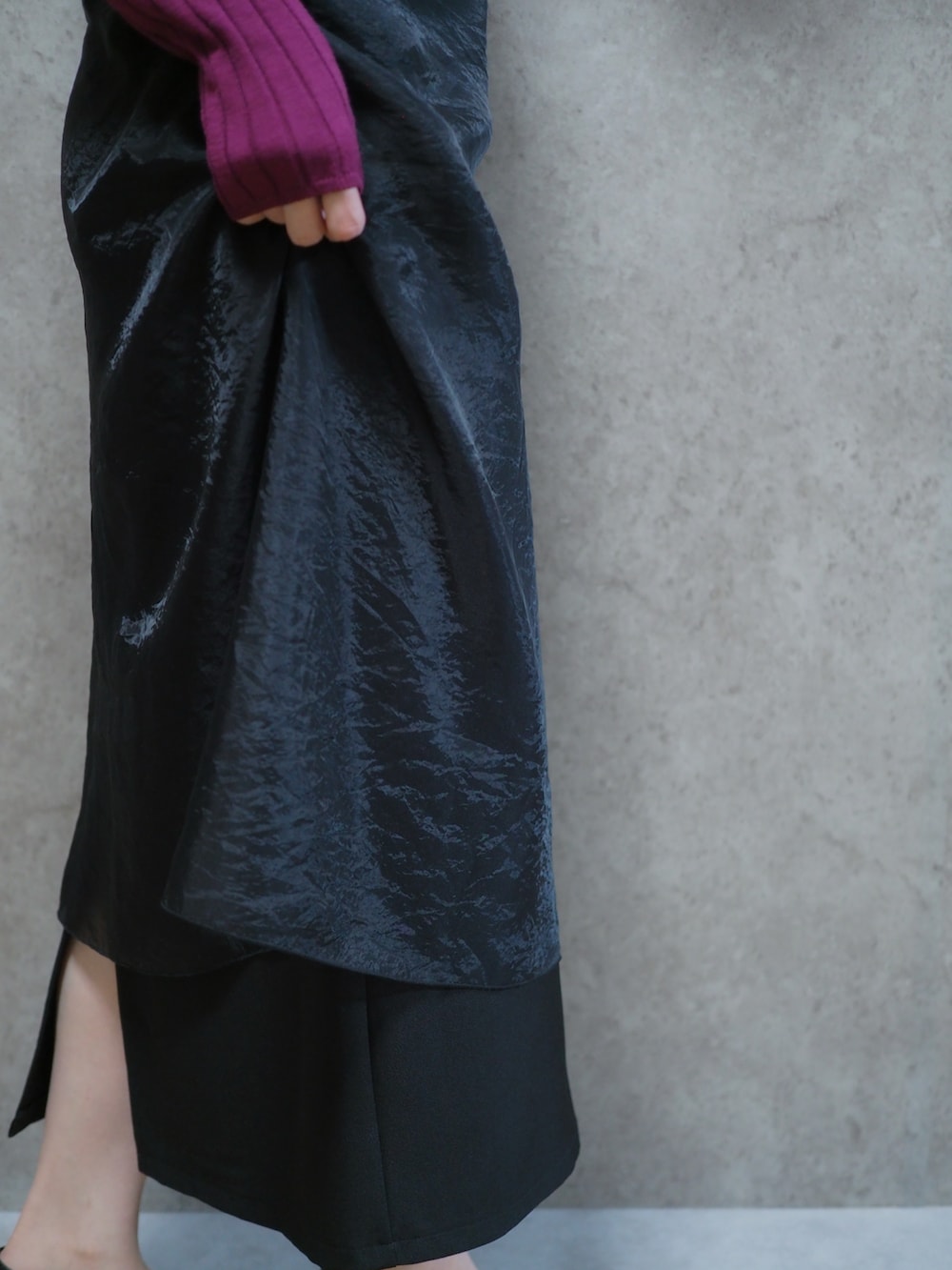 ブラック系のスカート、ピンク系のニット/セーター、ホワイト系のダウンジャケット/コートを着用したレディースの春コーディネートの2枚目の写真