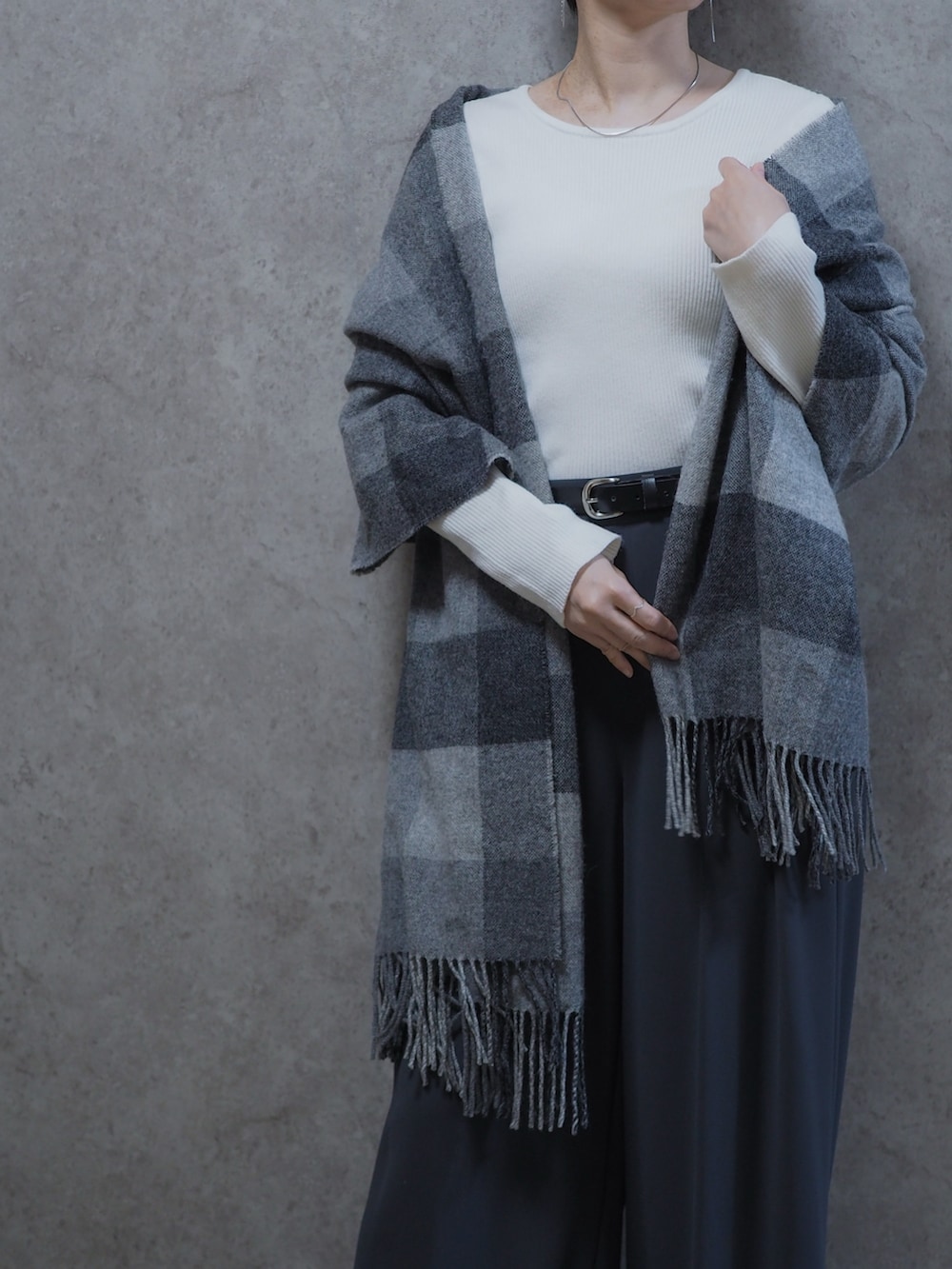 ホワイト系のニット/セーター、グレー系のスラックス、ブラック系のパンプスを着用したレディースの春コーディネートの2枚目の写真