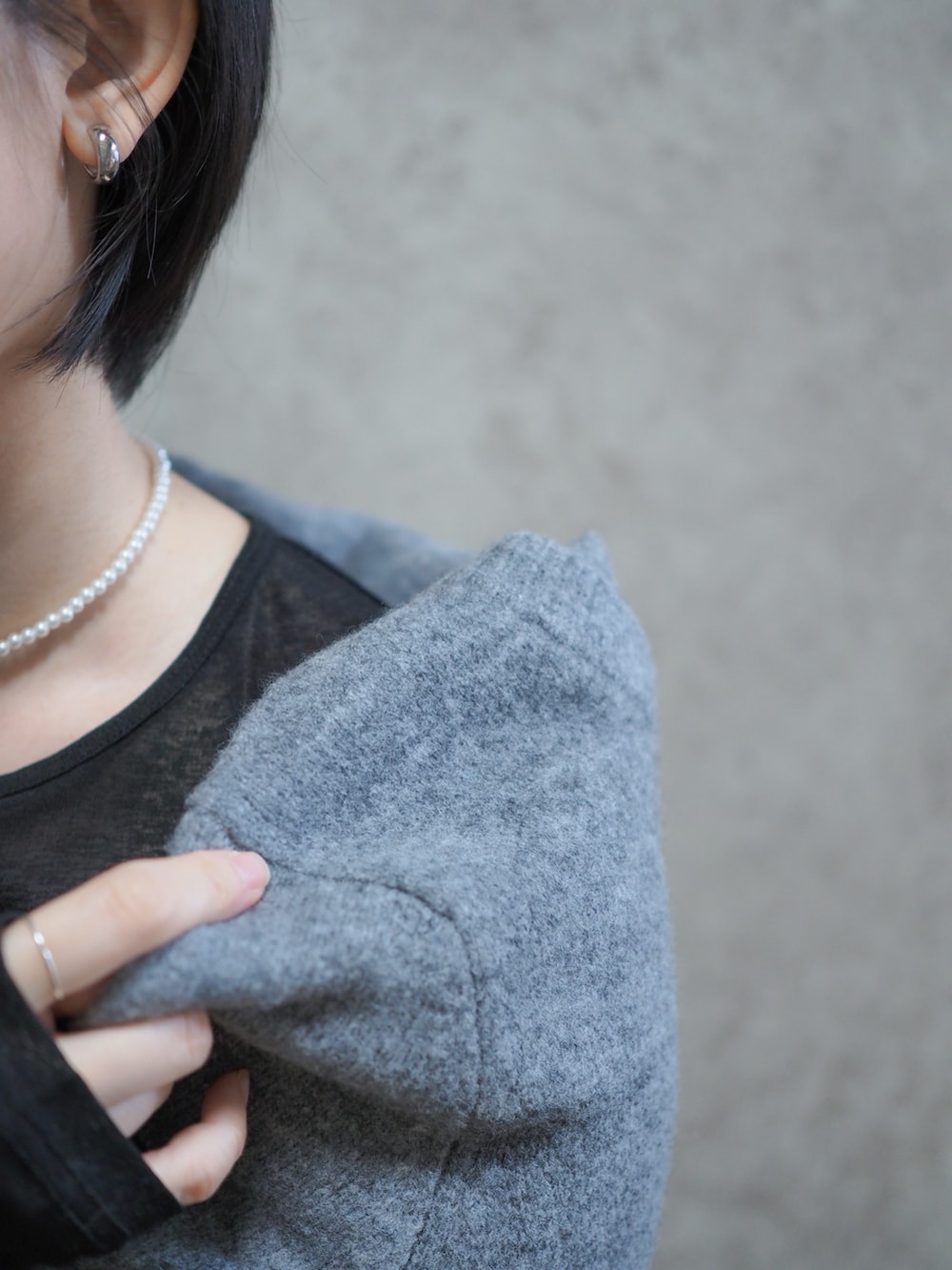 ブラック系のブーツ、グレー系のスラックス、グレー系のカーディガン/ボレロを着用したレディースの冬コーディネートの2枚目の写真