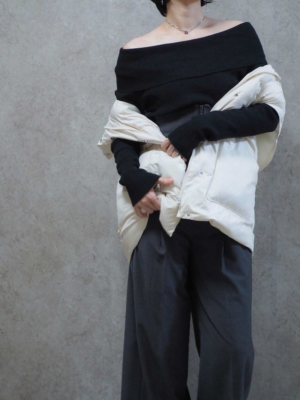 グレー系のスラックス、ブラック系のパンプス、ホワイト系のダウンジャケット/コートを着用したレディースの冬コーディネートの2枚目の写真