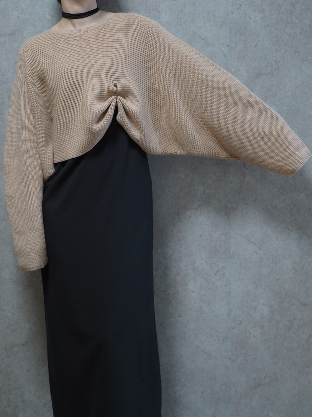 ブラック系のパンプス、ベージュ系のニット/セーター、ブラック系のワンピースを着用したレディースの春コーディネートの2枚目の写真