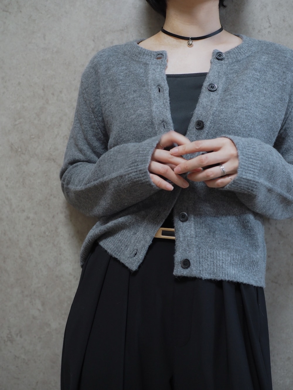 ブラック系のスラックス、ブラック系のパンプス、グレー系のカーディガン/ボレロを着用したレディースの冬コーディネートの3枚目の写真