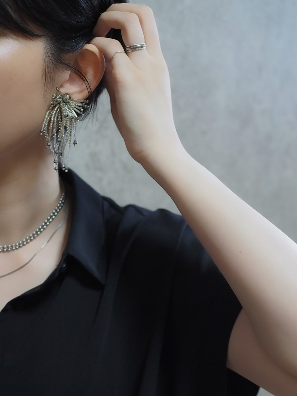 ブラック系のスカート、シルバー系のパンプス、グリーン系のスカートを着用したレディースの夏コーディネートの2枚目の写真
