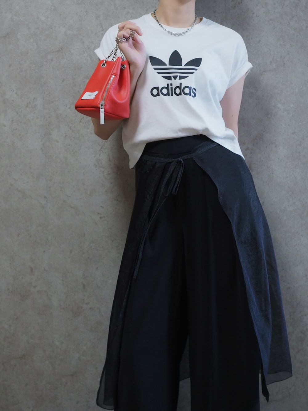 ブラック系のスカート、シルバー系のパンプス、ブラック系のスラックスを着用したレディースの夏コーディネートの2枚目の写真