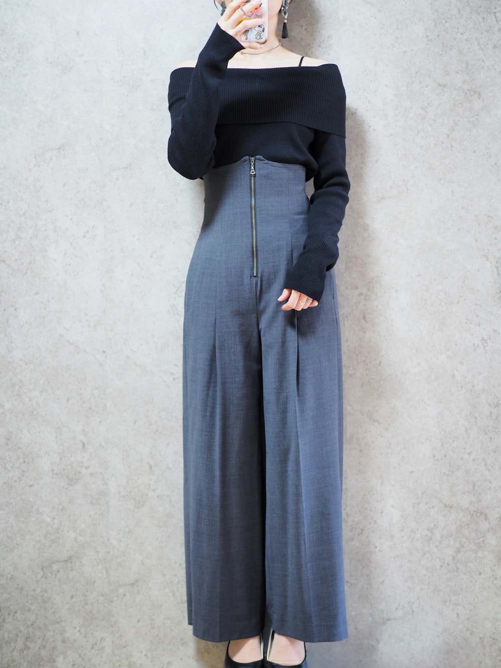 グレー系のスラックス、ホワイト系のダウンジャケット/コート、ブラック系のニット/セーターを着用したレディースの秋コーディネートの2枚目の写真