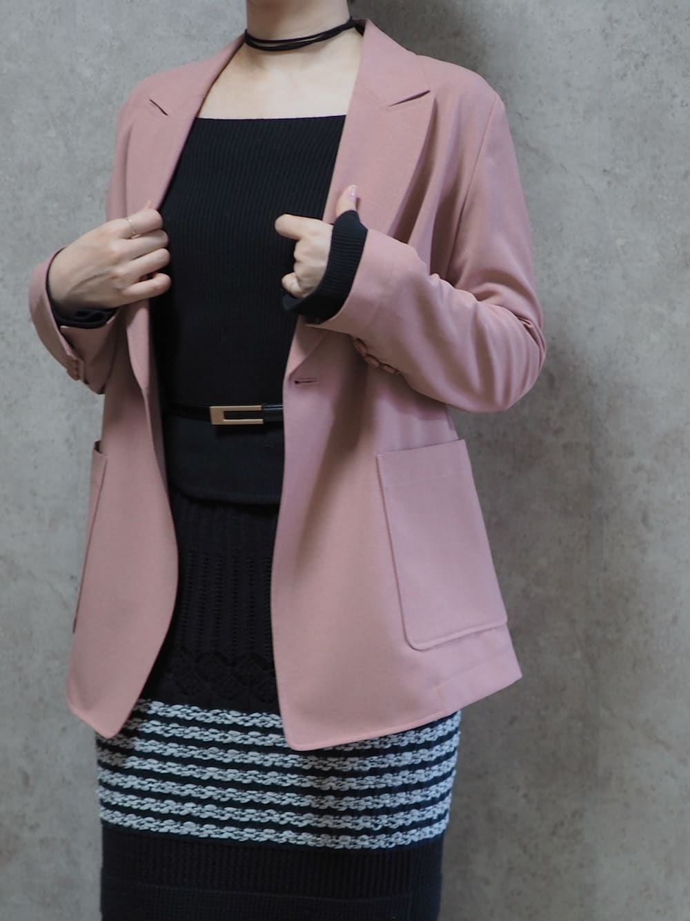 ブラック系のパンプス、ブラック系のスカート、ピンク系のテーラードジャケットを着用したレディースの春コーディネートの2枚目の写真