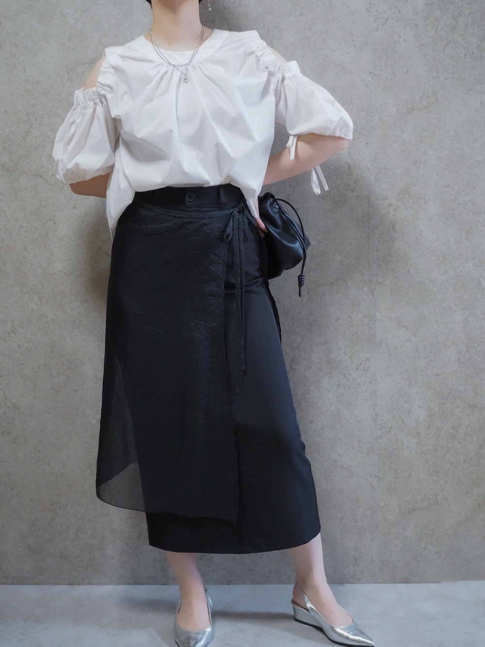 ブラック系のスカート、ホワイト系のシャツ/ブラウス、シルバー系のパンプスを着用したレディースの夏コーディネートの3枚目の写真