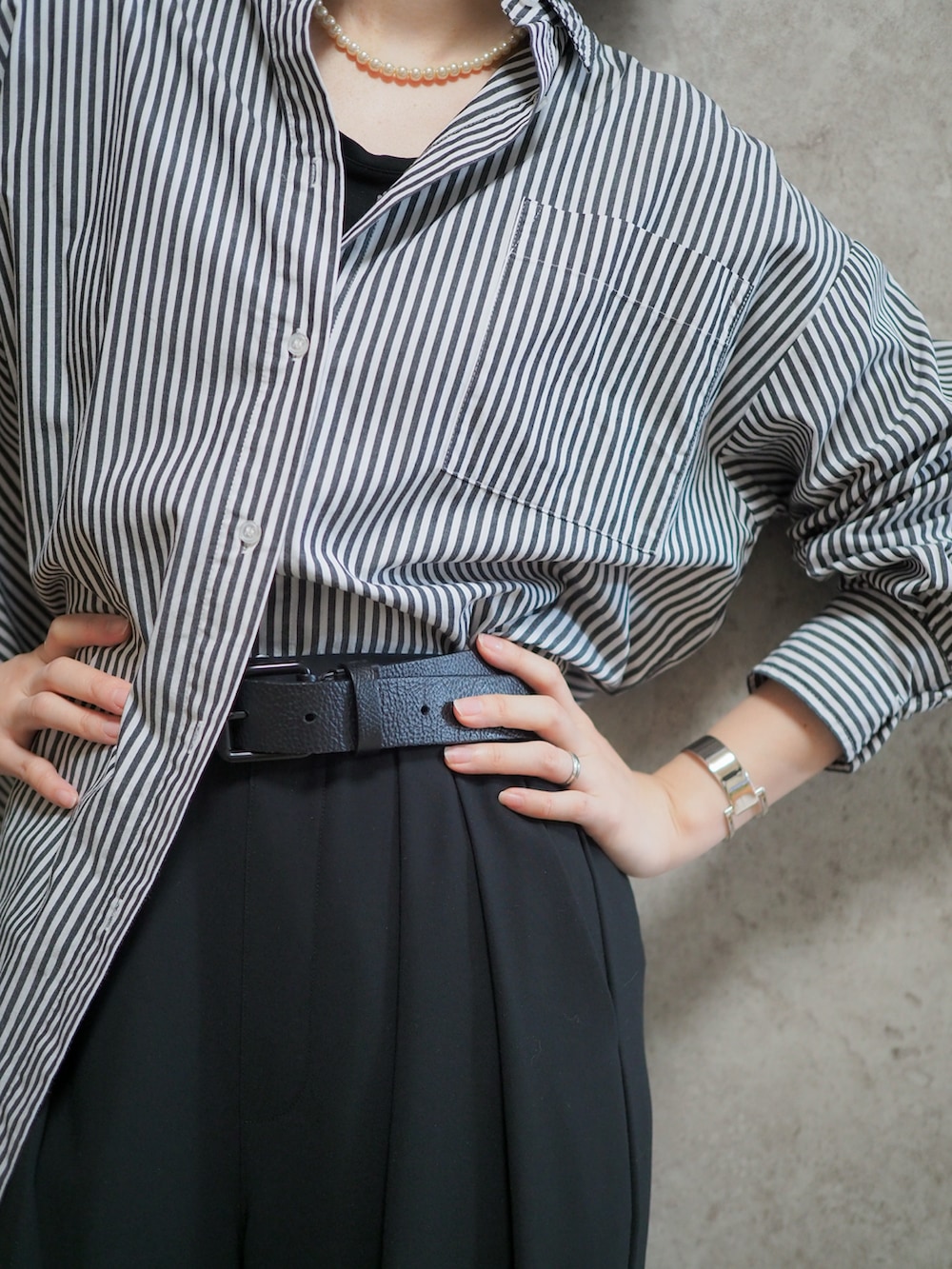 ブラック系のシャツ/ブラウス、ブラック系のチェスターコート、ブラック系のスラックスを着用したレディースの冬コーディネートの2枚目の写真