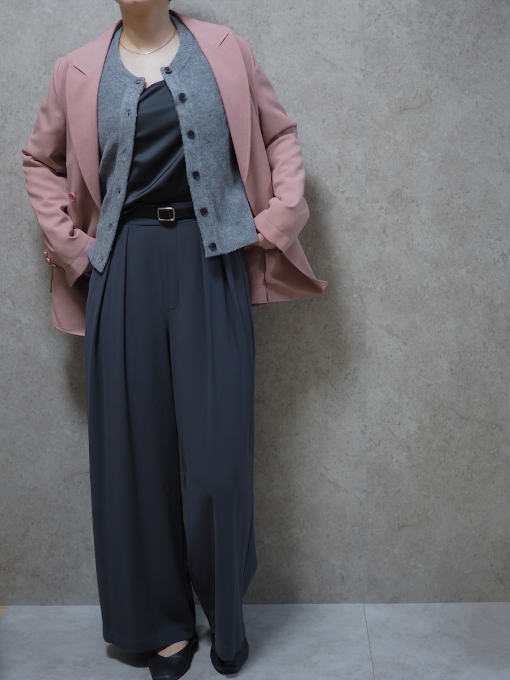 ピンク系のテーラードジャケット、グレー系のスラックス、ブラック系のパンプスを着用したレディースの春コーディネートの2枚目の写真