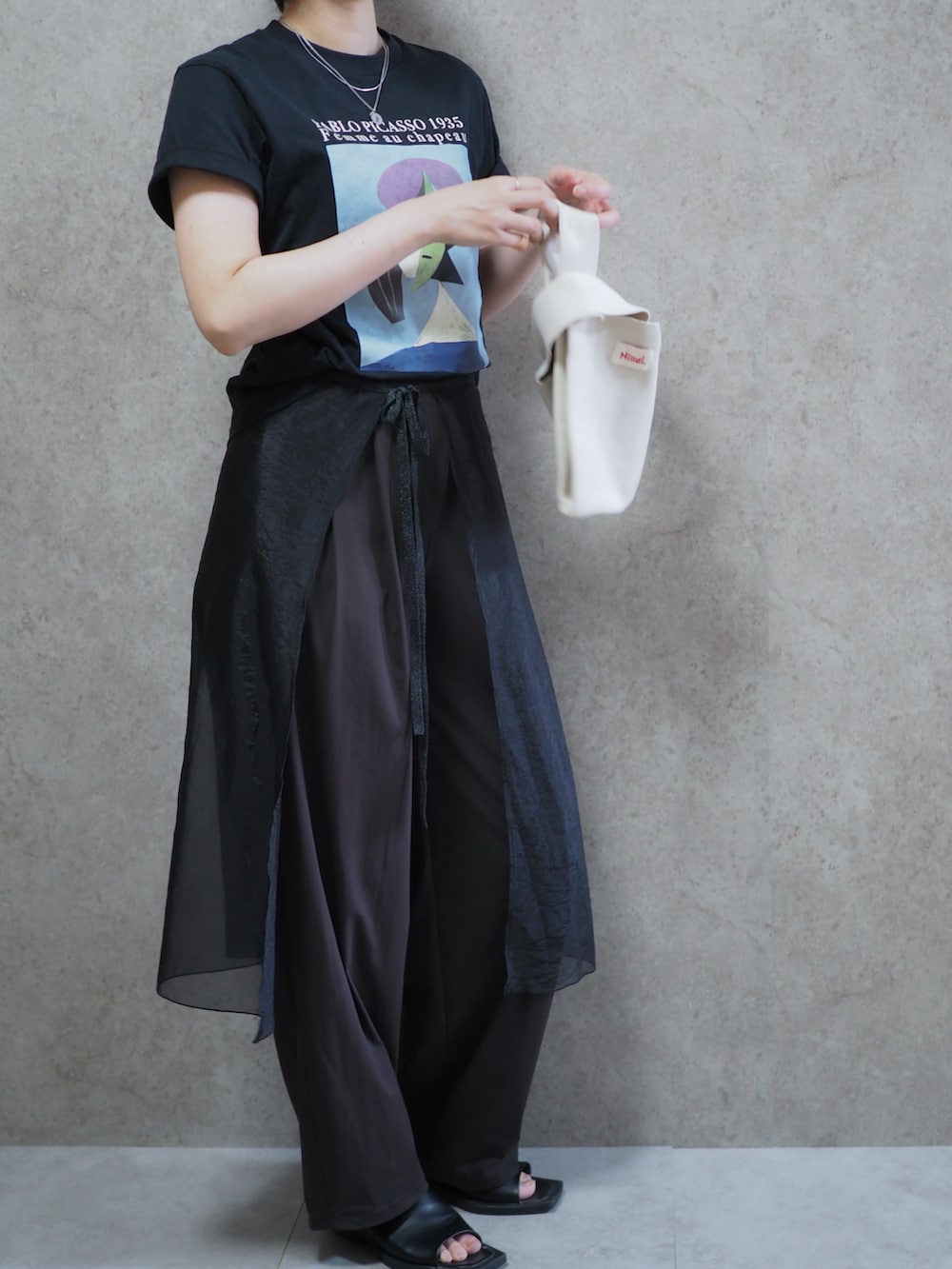 ブラック系のスカート、ブラック系のサンダル、ブラック系のTシャツ/カットソーを着用したレディースの春コーディネートの2枚目の写真