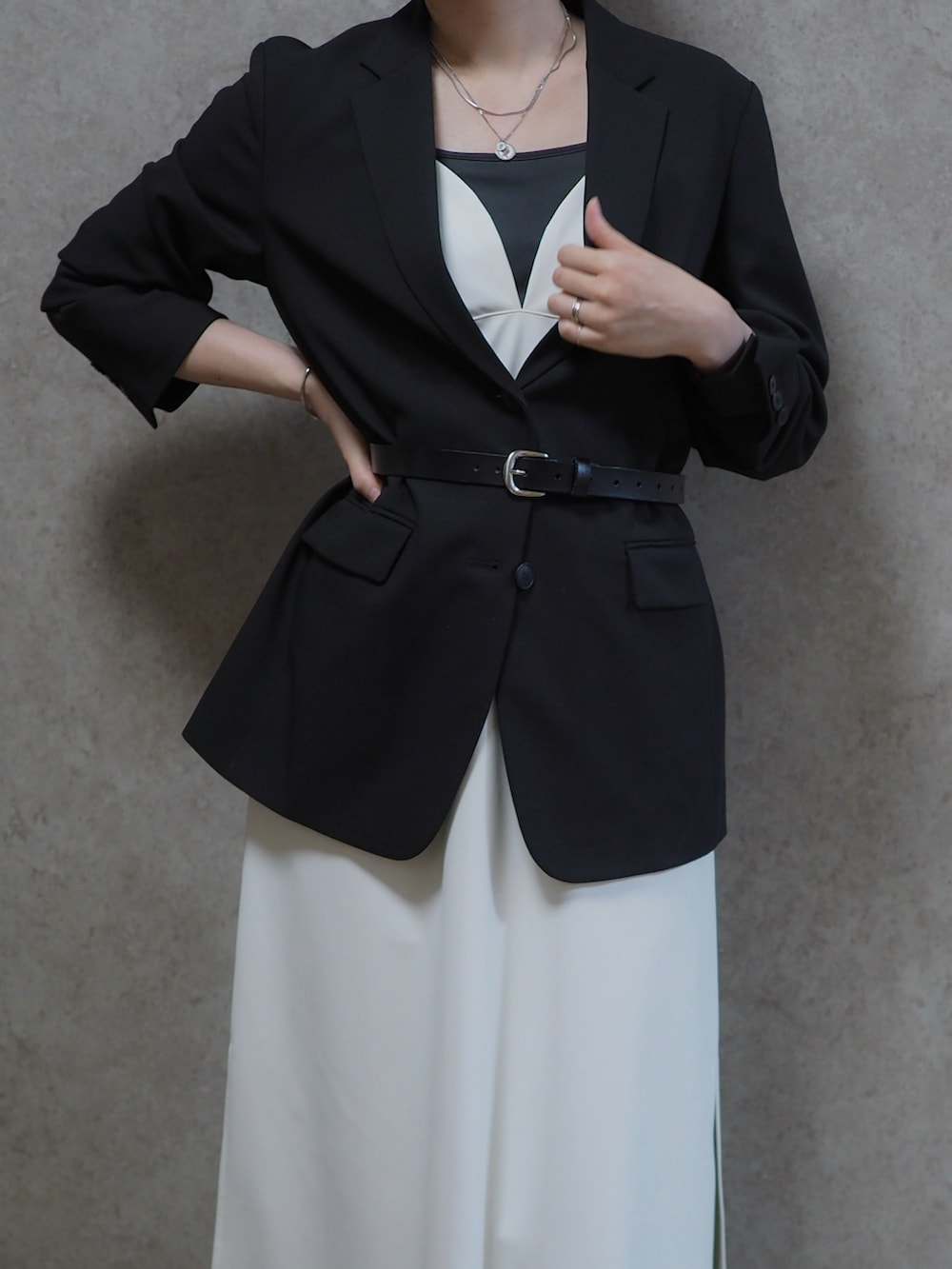 ブラック系のパンプス、ブラック系のキャミソール、ブラック系のテーラードジャケットを着用したレディースの春コーディネートの2枚目の写真