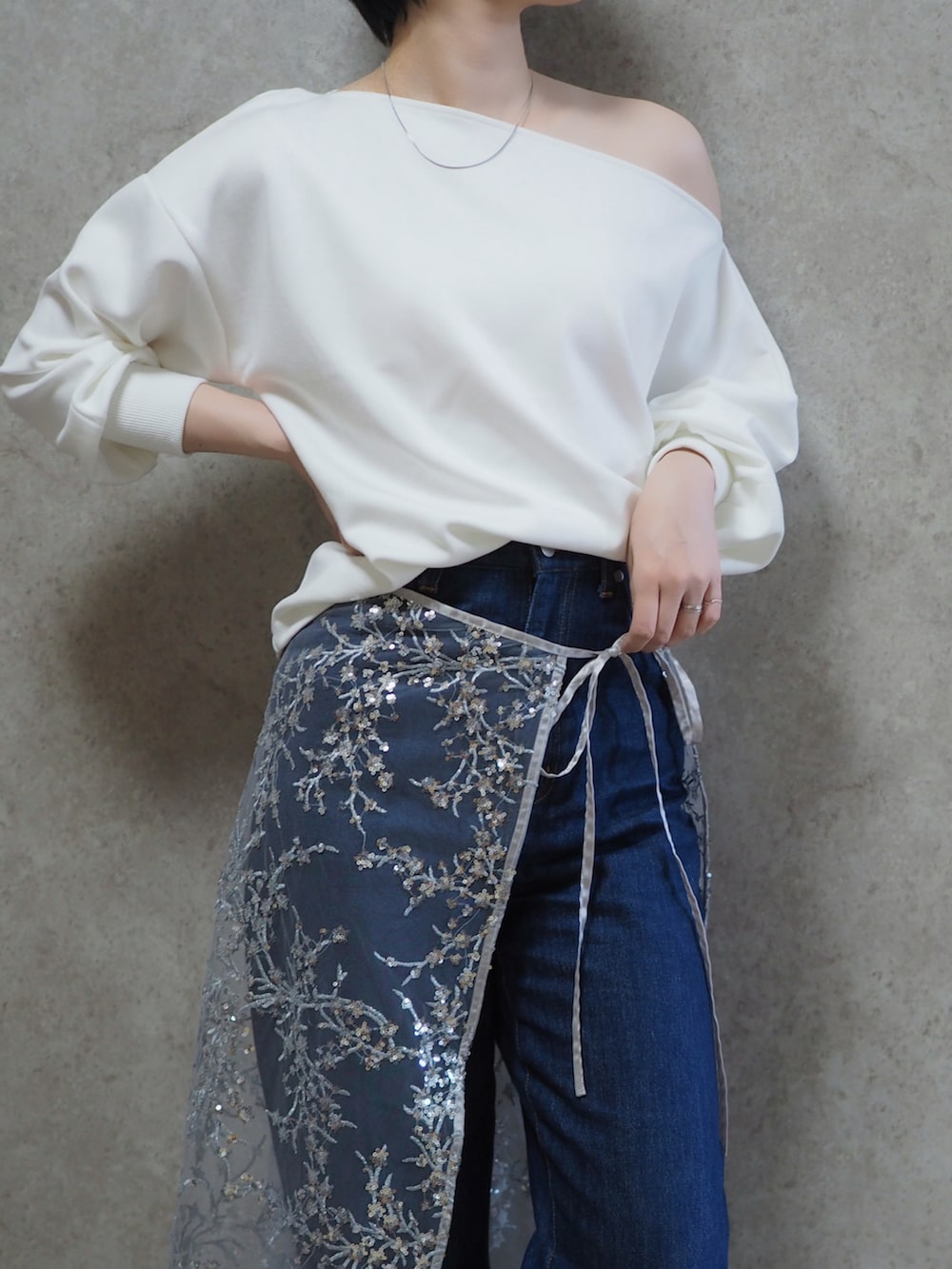 ホワイト系のTシャツ/カットソー、ブルー系のデニムパンツ、シルバー系のスカートを着用したレディースの春コーディネートの2枚目の写真