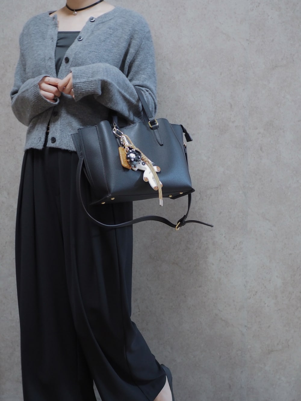 ブラック系のスラックス、ブラック系のパンプス、グレー系のカーディガン/ボレロを着用したレディースの冬コーディネートの2枚目の写真