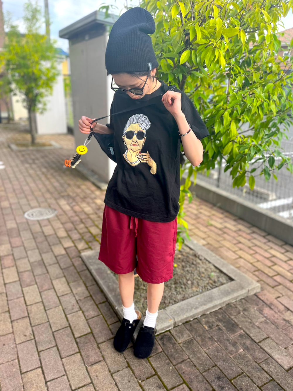 ブラック系のボディバッグ/ウエストポーチ、ブラック系のスリッポン、レッド系のパンツを着用したレディースの夏コーディネートの2枚目の写真