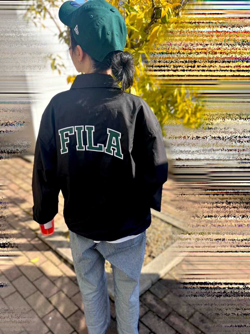 ブラック系のナイロンジャケット、ブラック系のスリッポン、ブルー系のその他パンツを着用したレディースの春コーディネートの2枚目の写真