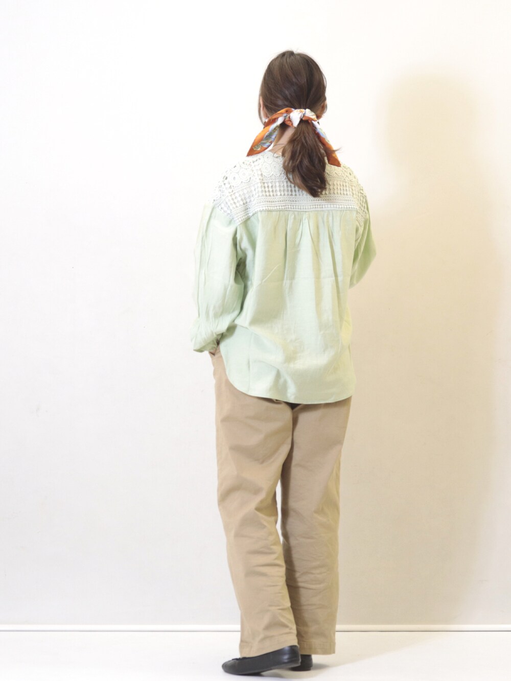 グリーン系のシャツ/ブラウス、ベージュ系のパンツを着用したレディースの春コーディネートの2枚目の写真