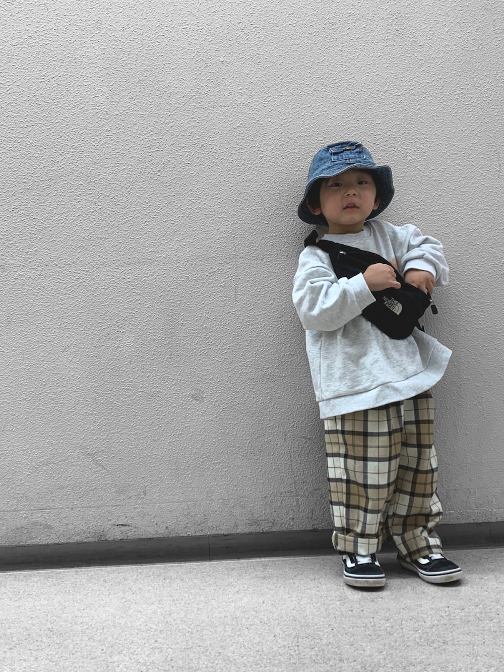 ブラック系のボディバッグ/ウエストポーチ、ブラック系のスニーカー、ホワイト系のスウェットを着用したキッズの春コーディネートの3枚目の写真