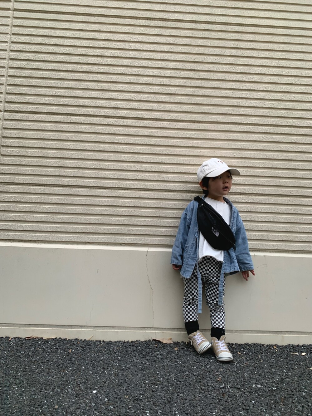 ブラック系のボディバッグ/ウエストポーチ、ベージュ系のスニーカー、ブルー系のデニムジャケットを着用したキッズの春コーディネートの2枚目の写真