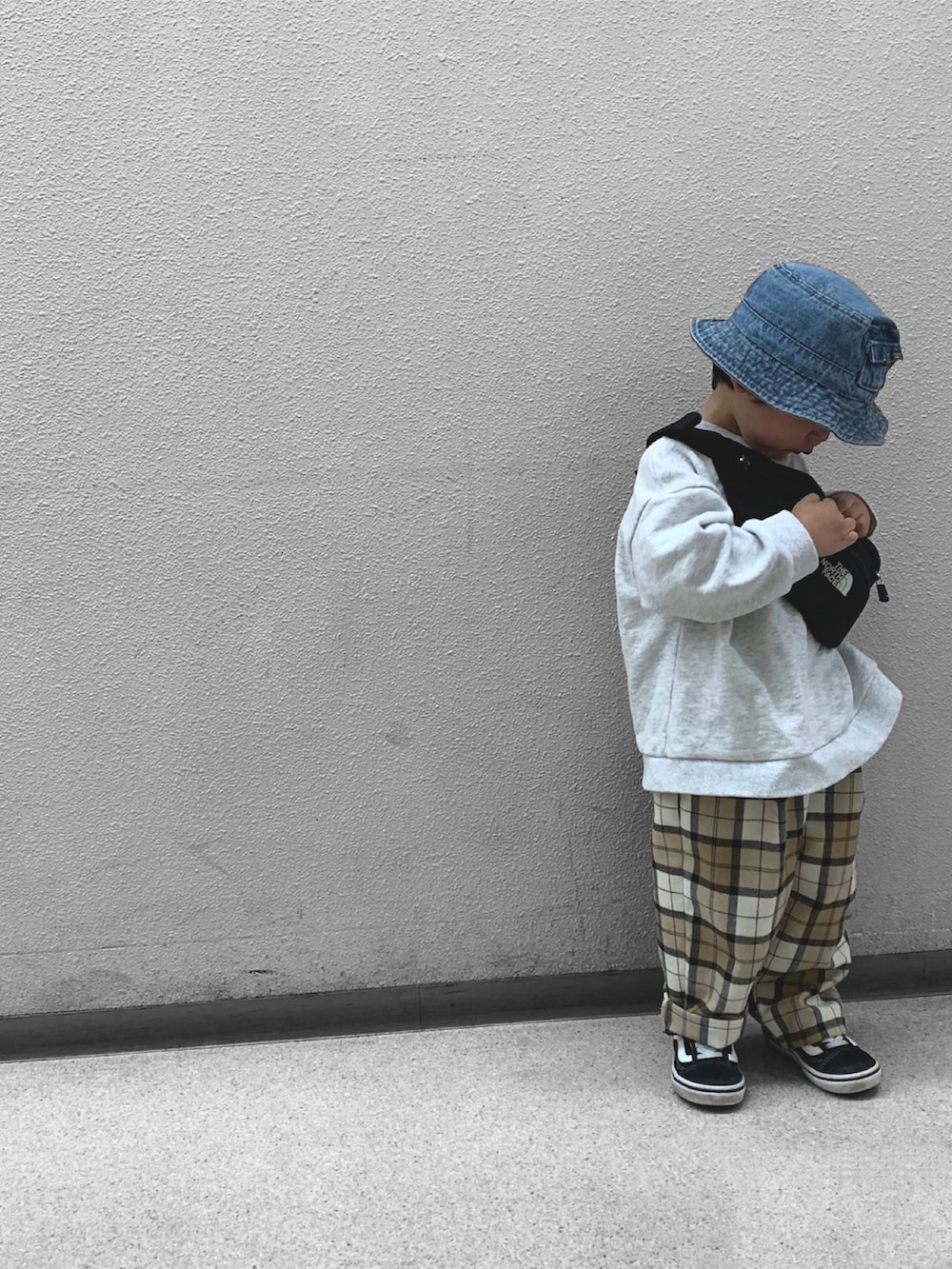 ブラック系のボディバッグ/ウエストポーチ、ブラック系のスニーカー、ホワイト系のスウェットを着用したキッズの春コーディネートの2枚目の写真