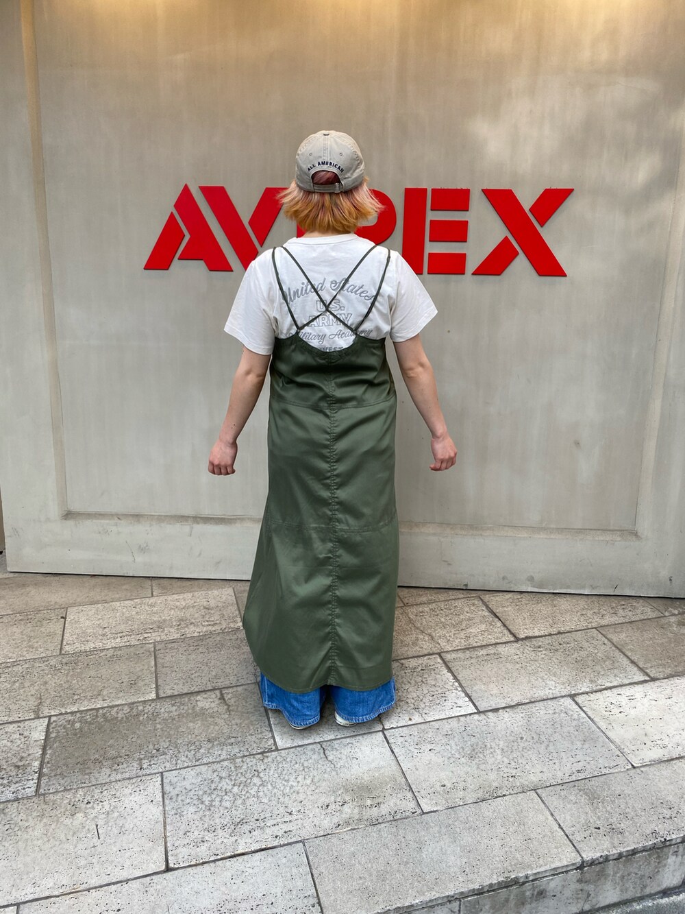 グリーン系のワンピース、ホワイト系のTシャツ/カットソーを着用したレディースの夏コーディネートの2枚目の写真