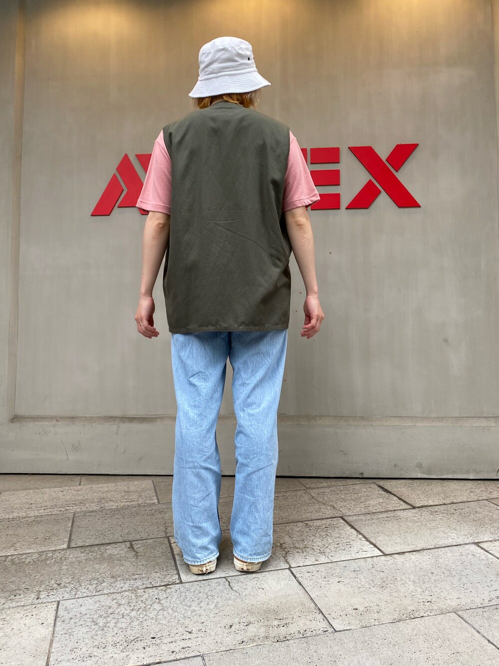 グリーン系のベスト、ホワイト系のTシャツ/カットソーを着用したレディースの夏コーディネートの2枚目の写真