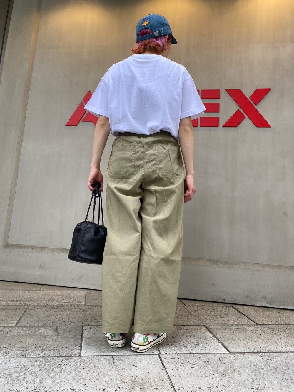グリーン系のその他パンツ、ホワイト系のTシャツ/カットソー、ブラック系のショルダーバッグを着用したレディースの春コーディネートの2枚目の写真