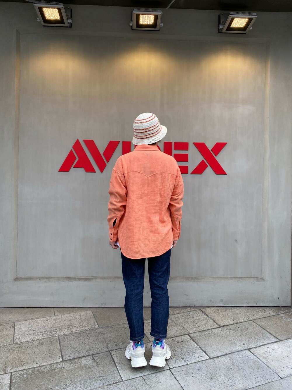 ホワイト系のTシャツ/カットソー、オレンジ系のシャツ/ブラウス、ホワイト系のハットを着用したレディースの春コーディネートの2枚目の写真