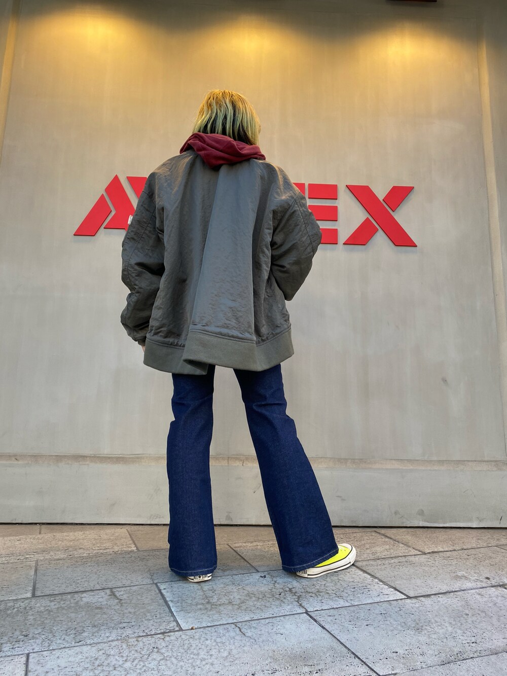 その他のデニムパンツ、レッド系のパーカー、グリーン系のMA-1を着用したレディースの冬コーディネートの3枚目の写真
