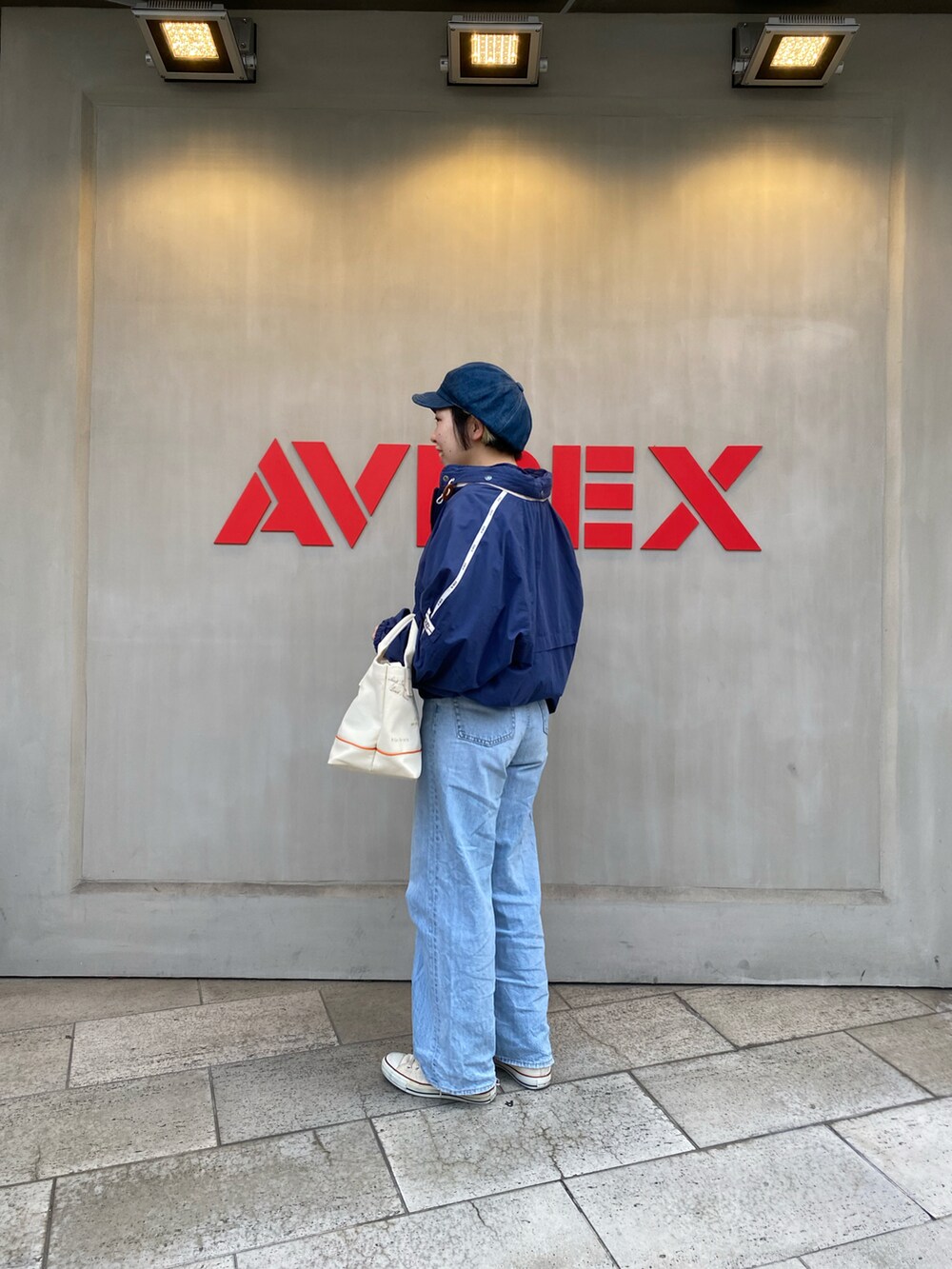 ホワイト系のトートバッグ、ブルー系のブルゾンを着用したレディースの春コーディネートの2枚目の写真