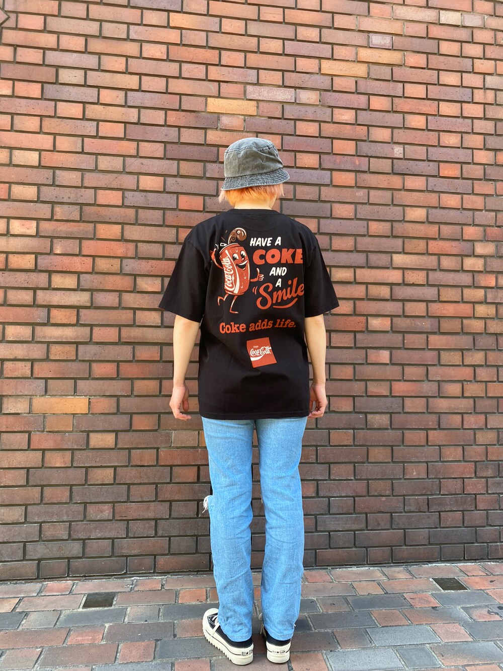 ブラック系のTシャツ/カットソー、ブラック系のハットを着用したレディースの春コーディネートの2枚目の写真