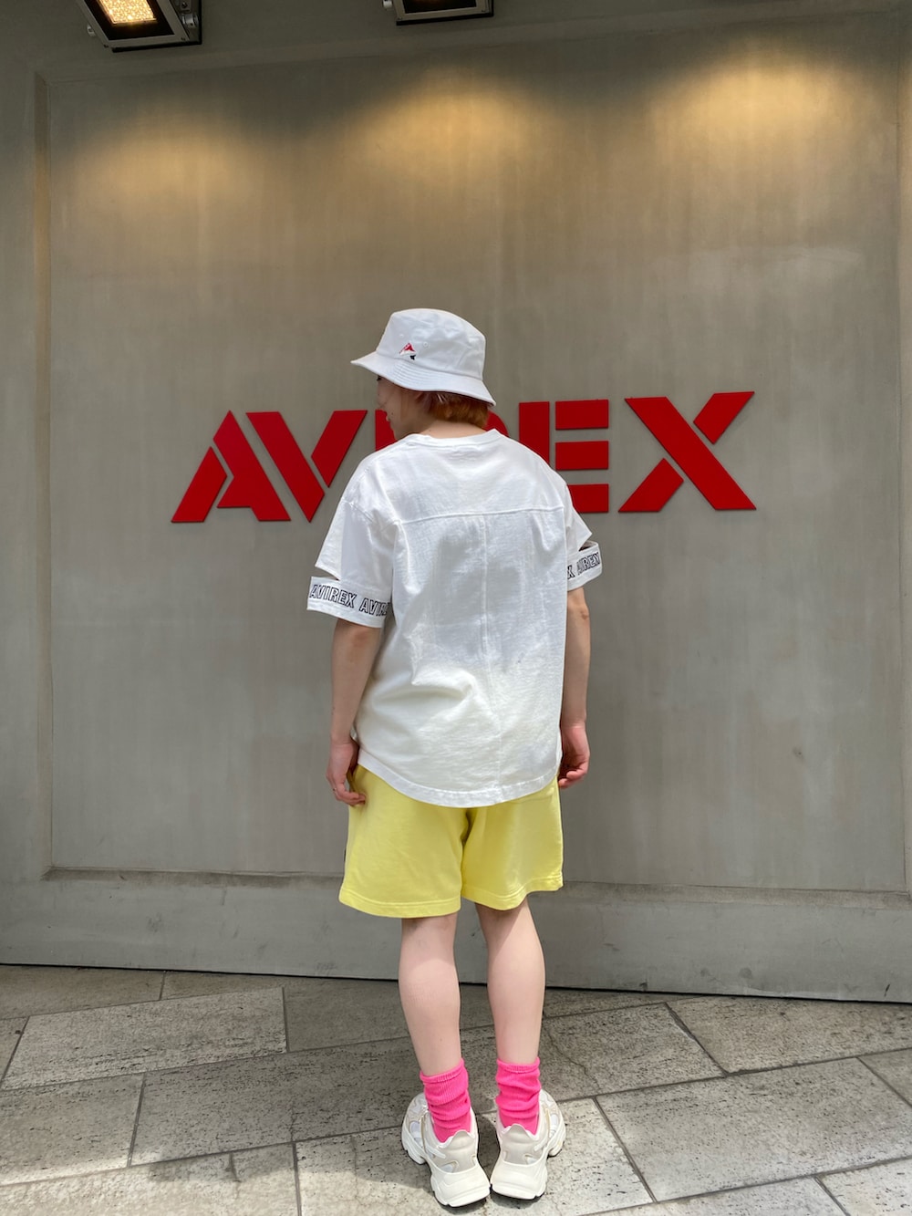 ホワイト系のTシャツ/カットソー、イエロー系のスウェットパンツ、ホワイト系のハットを着用したレディースの春コーディネートの2枚目の写真