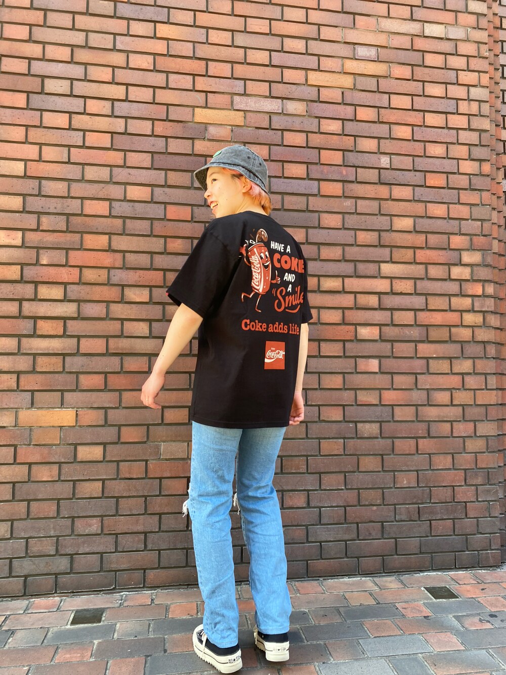 ブラック系のTシャツ/カットソー、ブラック系のハットを着用したレディースの春コーディネートの3枚目の写真