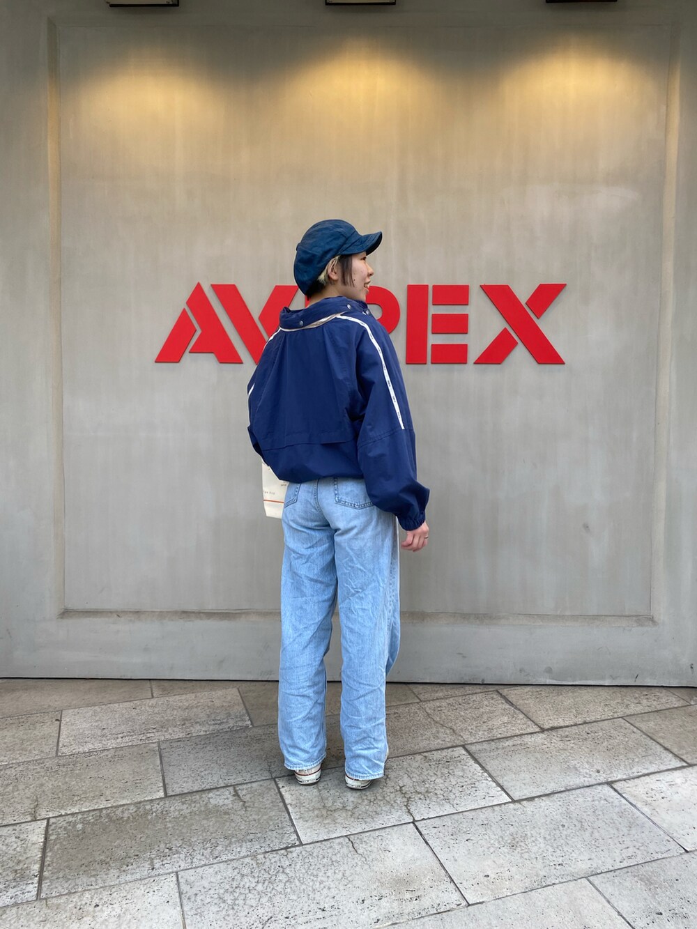 ホワイト系のトートバッグ、ブルー系のブルゾンを着用したレディースの春コーディネートの3枚目の写真