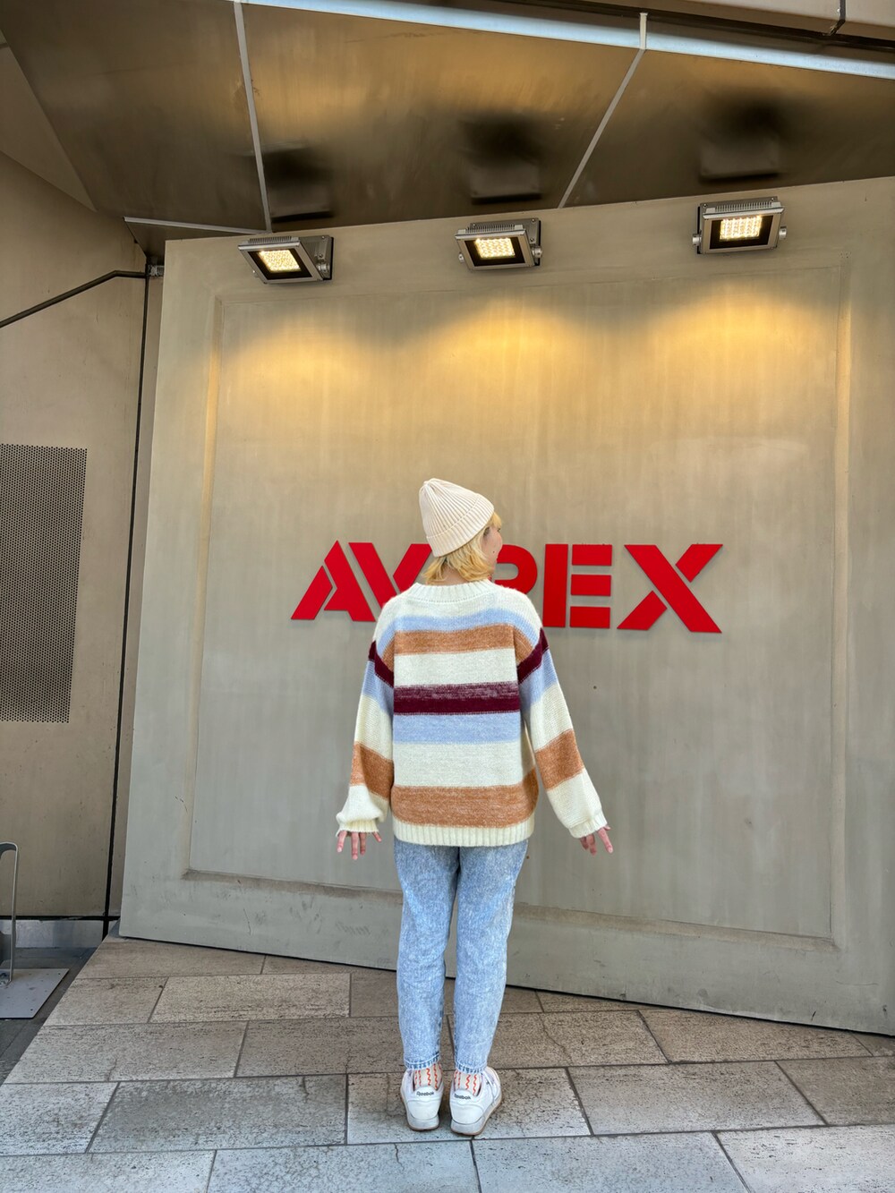 ホワイト系のニット/セーター、ホワイト系のニットキャップ/ビーニーを着用したレディースの秋コーディネートの2枚目の写真