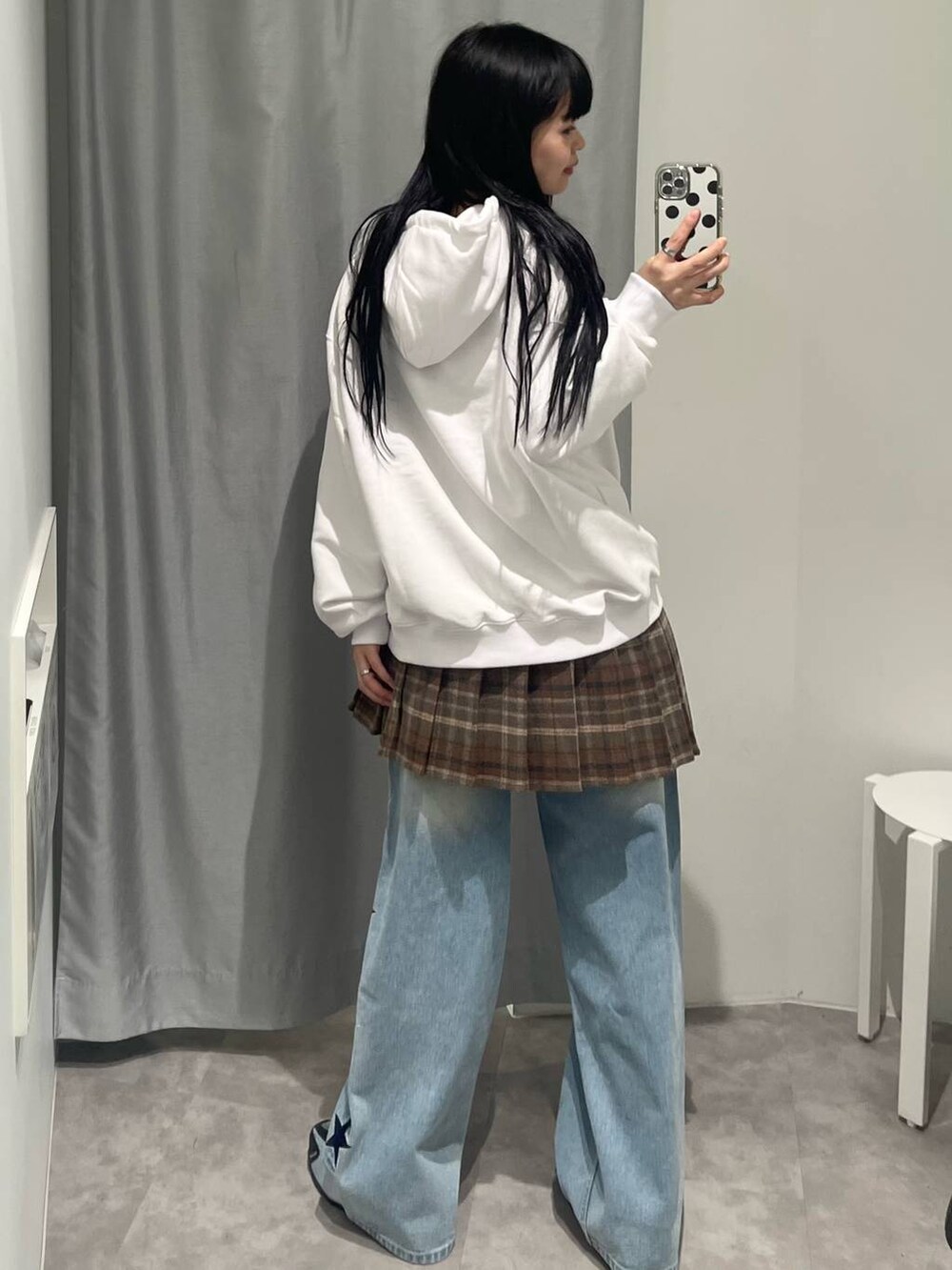 ブルー系のデニムパンツ、ブラウン系のスカート、ベージュ系のパーカーを着用したレディースの秋コーディネートの3枚目の写真