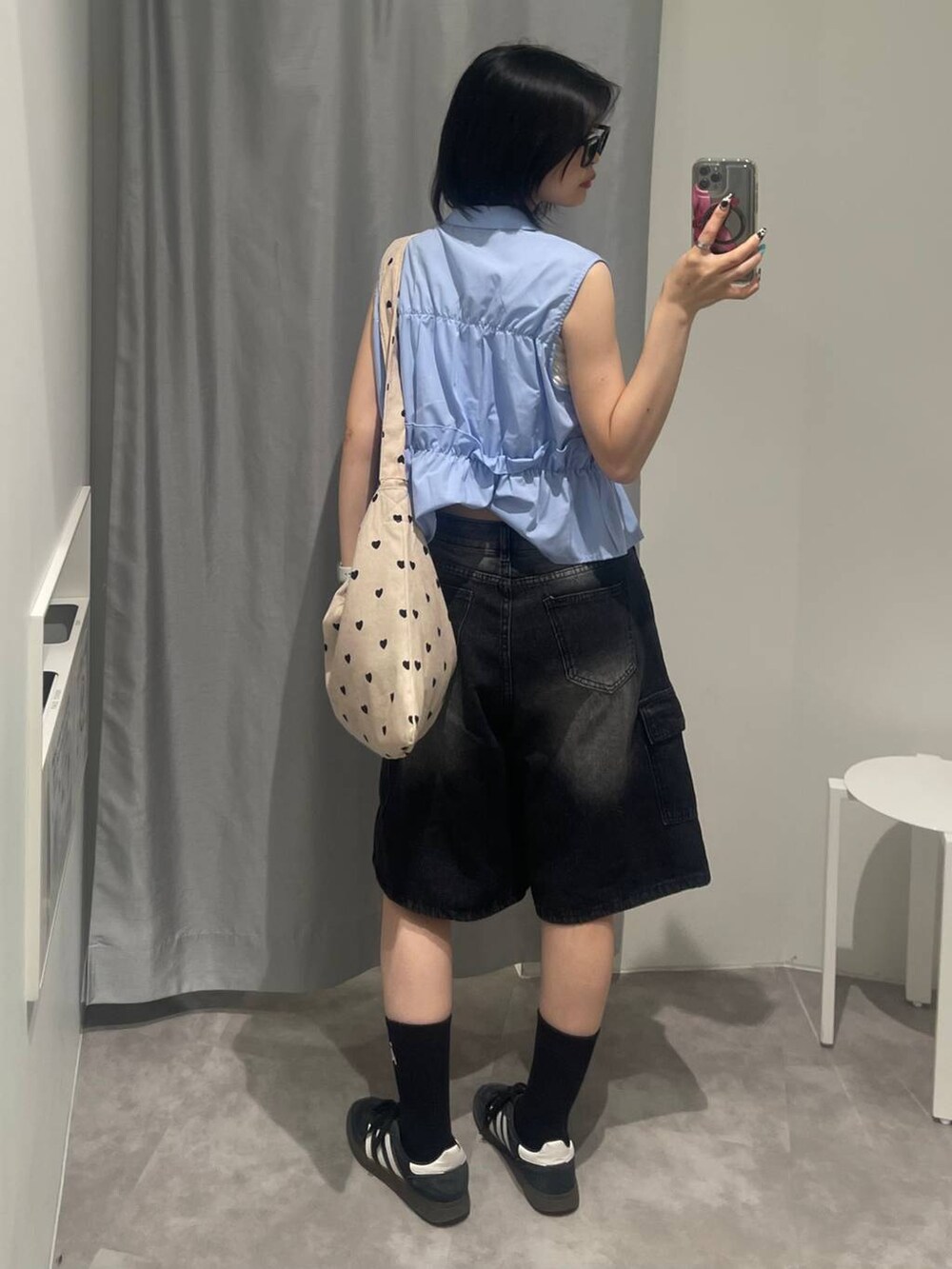 ブラック系のスニーカー、ブラック系のデニムパンツ、その他のトートバッグを着用したレディースの夏コーディネートの3枚目の写真