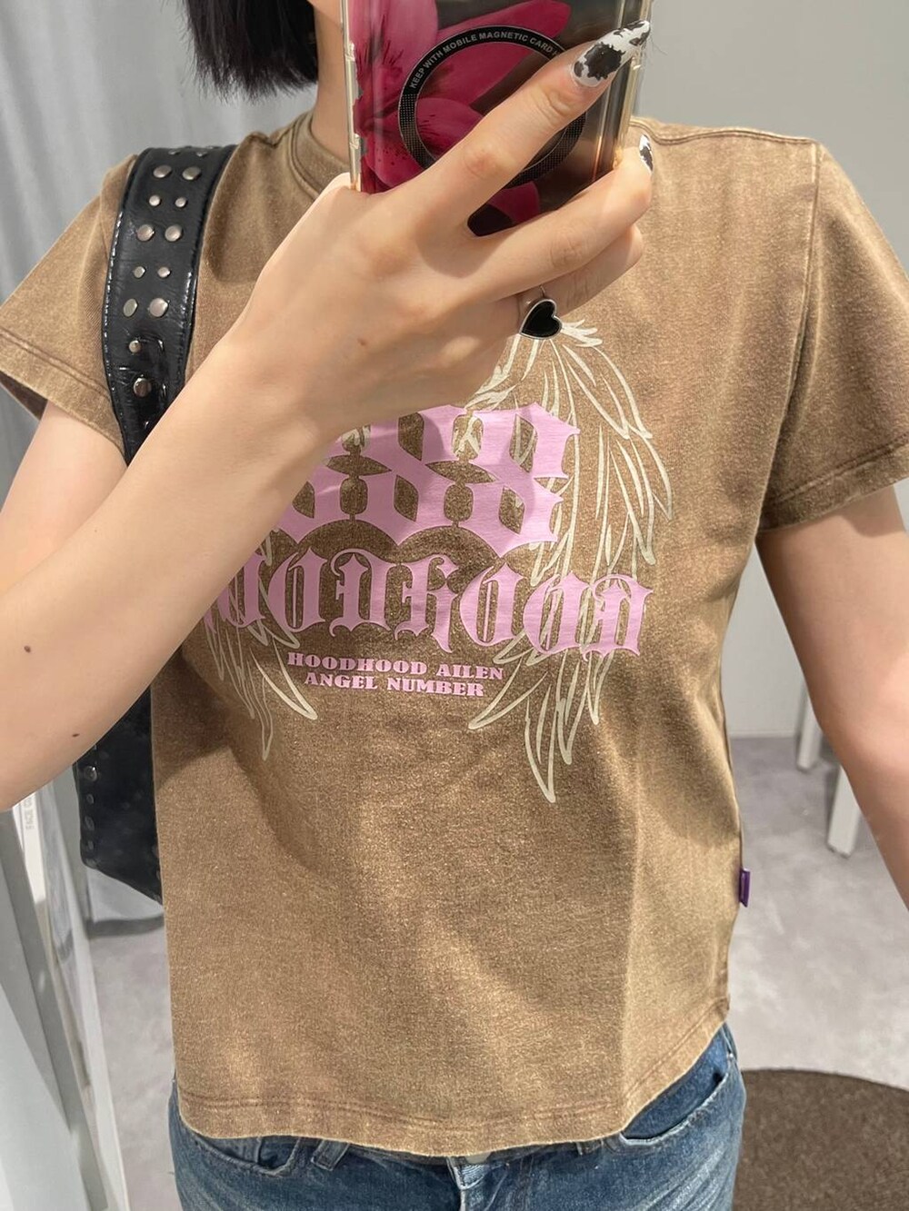 ブルー系のデニムパンツ、ブラック系のハンドバッグ、ブラック系のサングラスを着用したレディースの夏コーディネートの2枚目の写真