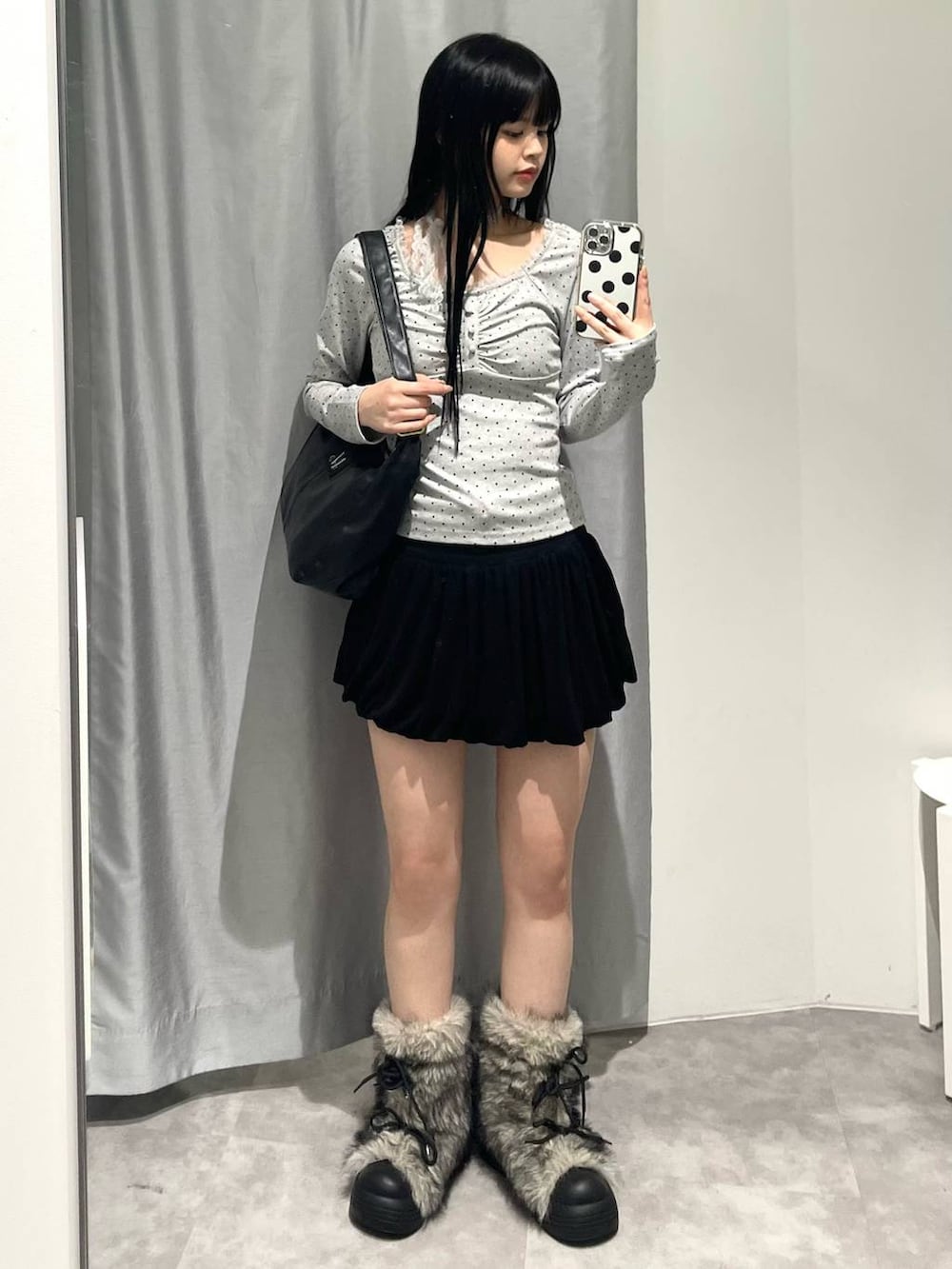 ブラック系のトートバッグ、ブラック系のスカート、グレー系のTシャツ/カットソーを着用したレディースの秋コーディネートの2枚目の写真