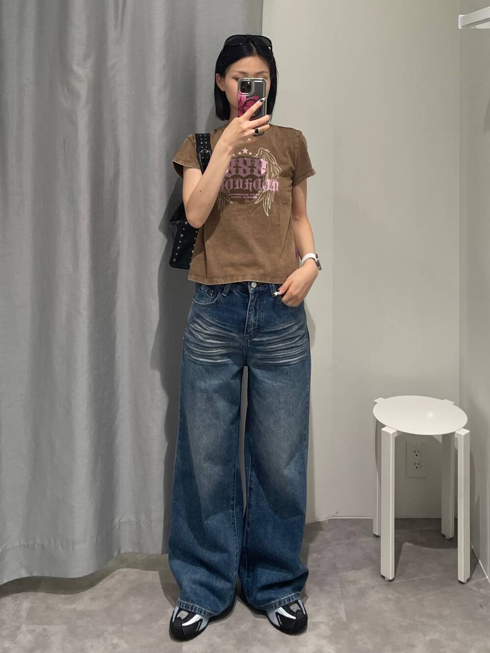 ブルー系のデニムパンツ、ブラック系のハンドバッグ、ブラック系のサングラスを着用したレディースの夏コーディネートの4枚目の写真