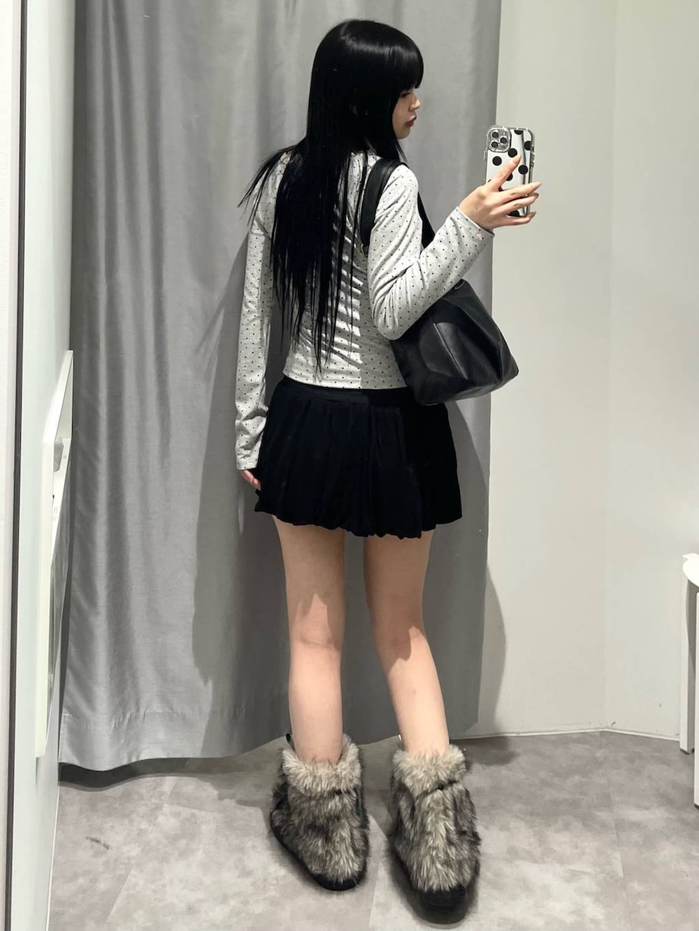 ブラック系のトートバッグ、ブラック系のスカート、グレー系のTシャツ/カットソーを着用したレディースの秋コーディネートの3枚目の写真