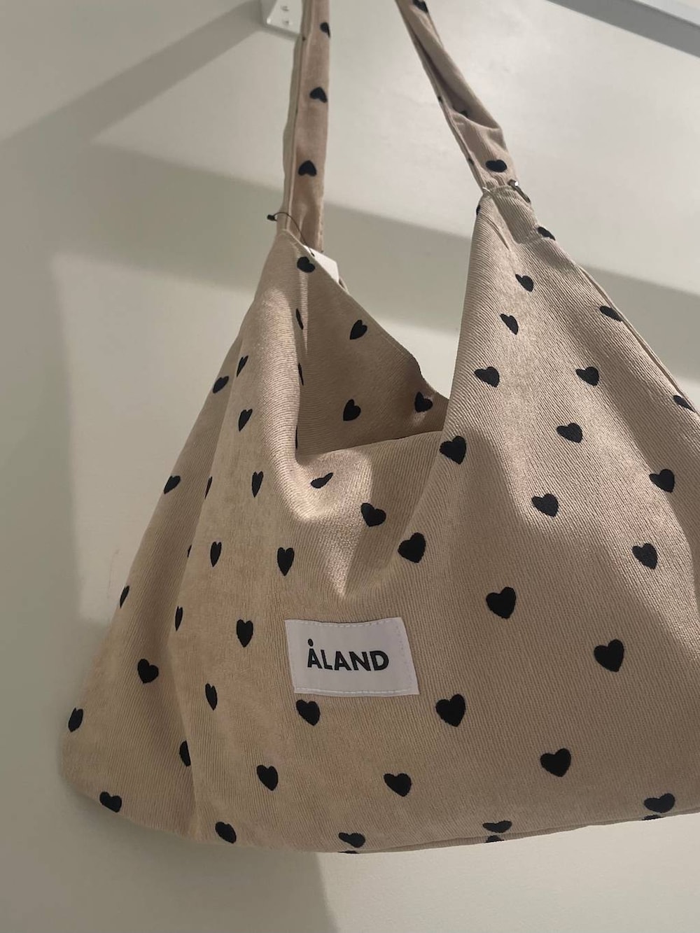 ブラック系のスニーカー、ブラック系のデニムパンツ、その他のトートバッグを着用したレディースの夏コーディネートの5枚目の写真