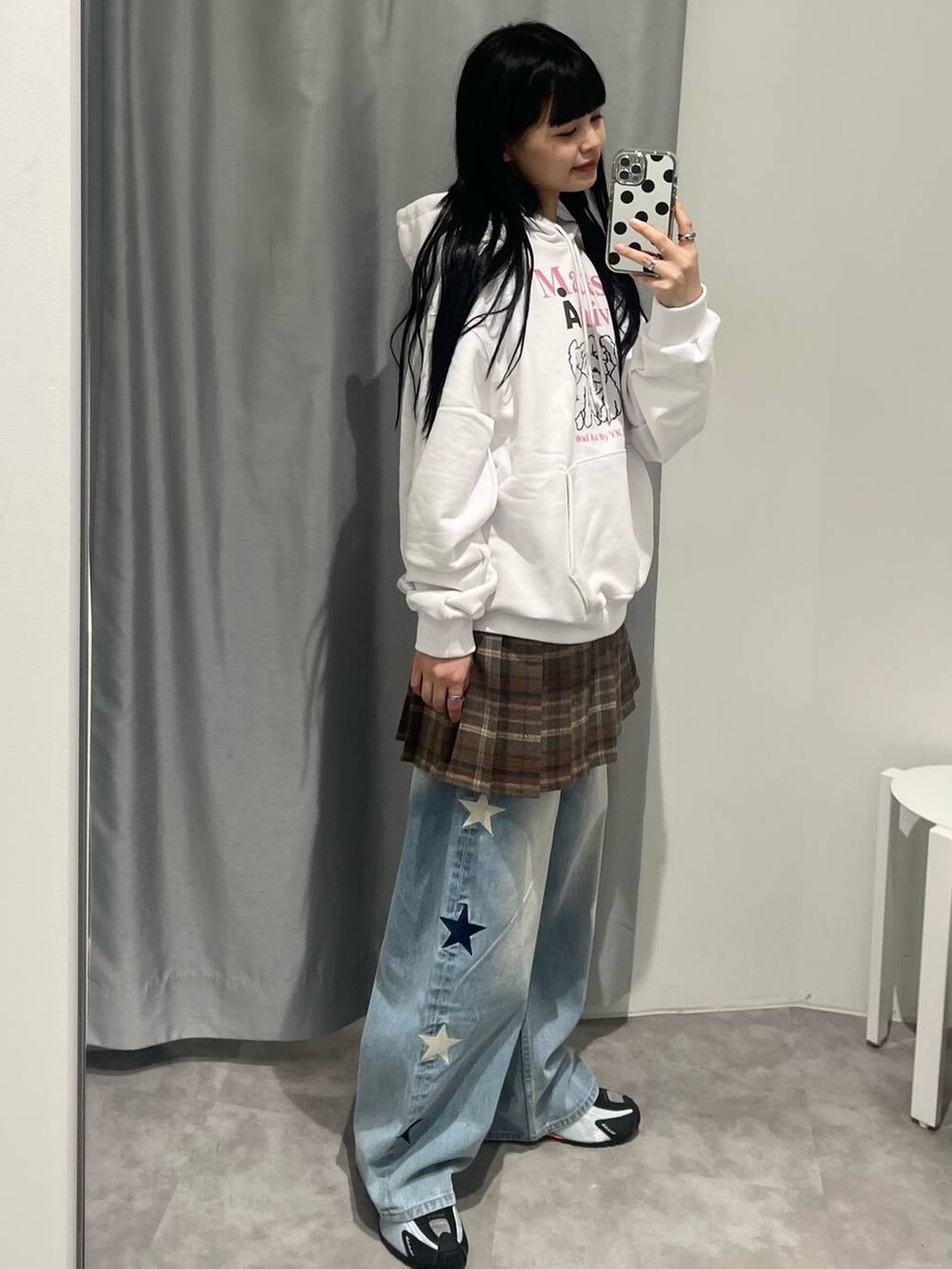 ブルー系のデニムパンツ、ブラウン系のスカート、ベージュ系のパーカーを着用したレディースの秋コーディネートの2枚目の写真