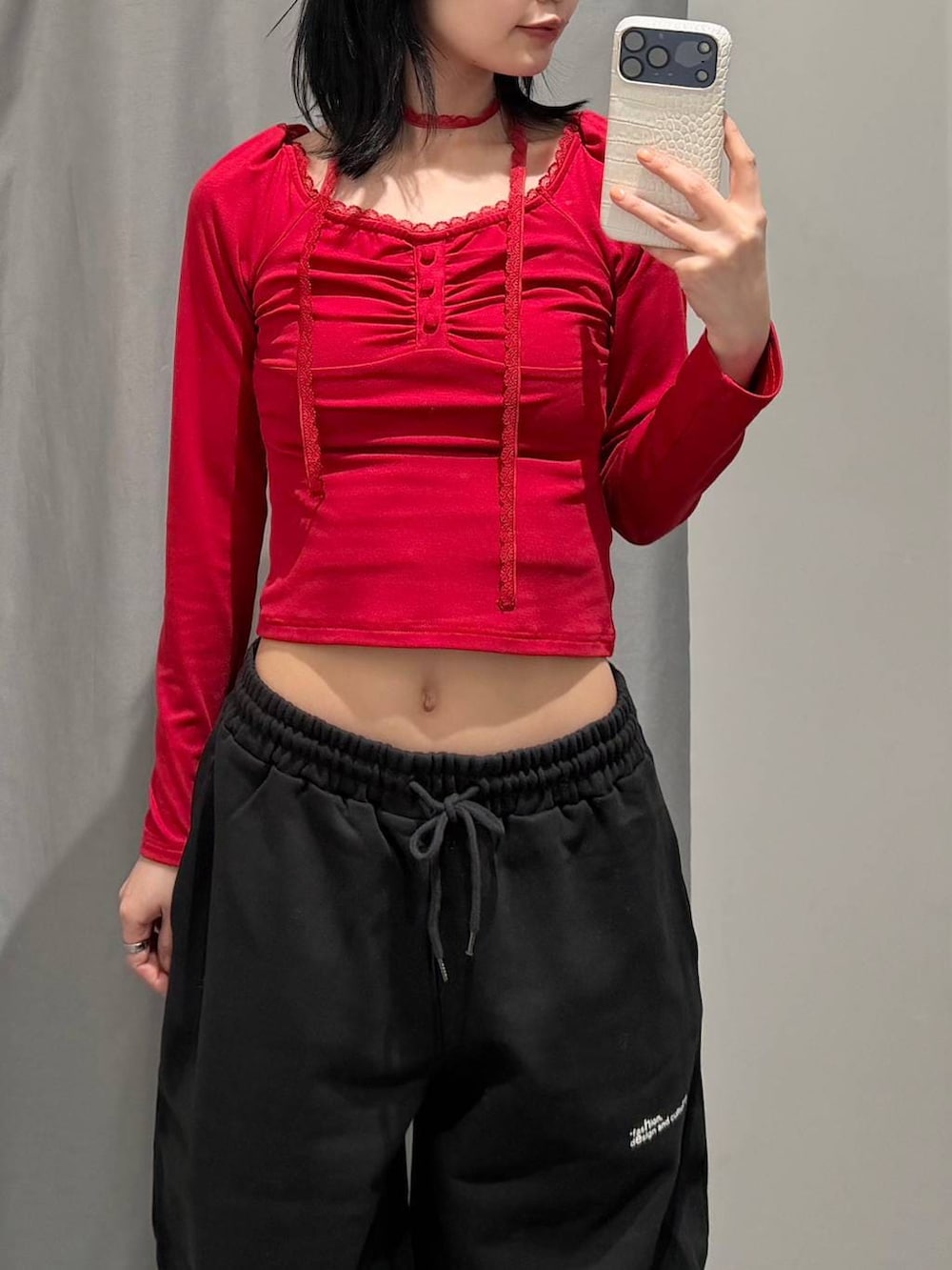 レッド系のTシャツ/カットソー、ブラック系のスウェットパンツ、ブラック系のブーツを着用したレディースの冬コーディネートの5枚目の写真