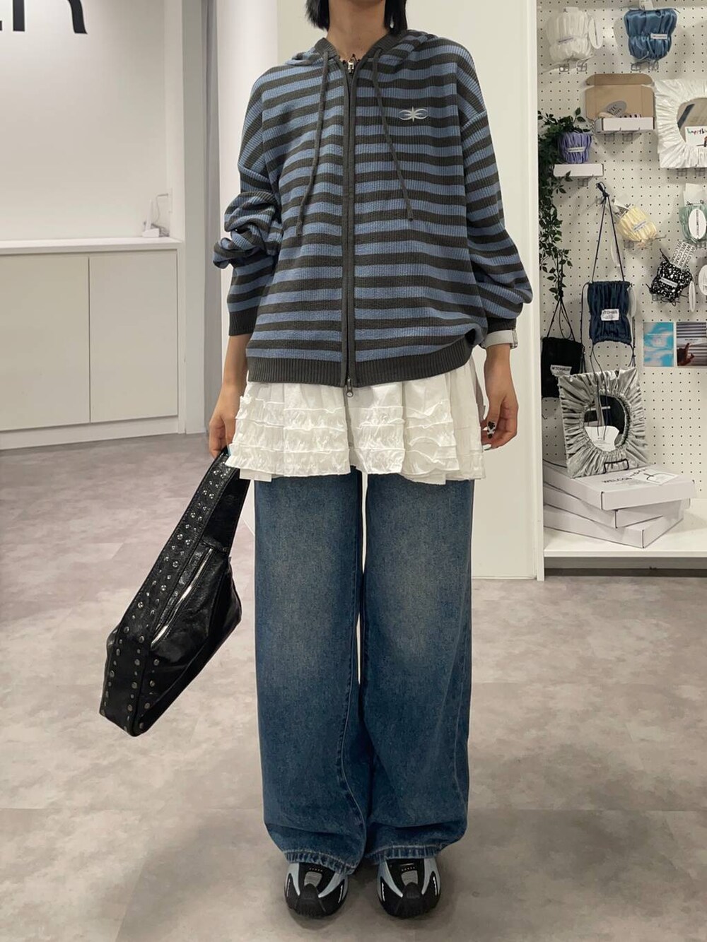 ブルー系のデニムパンツ、ブルー系のパーカー、ホワイト系のスカートを着用したレディースの夏コーディネートの6枚目の写真