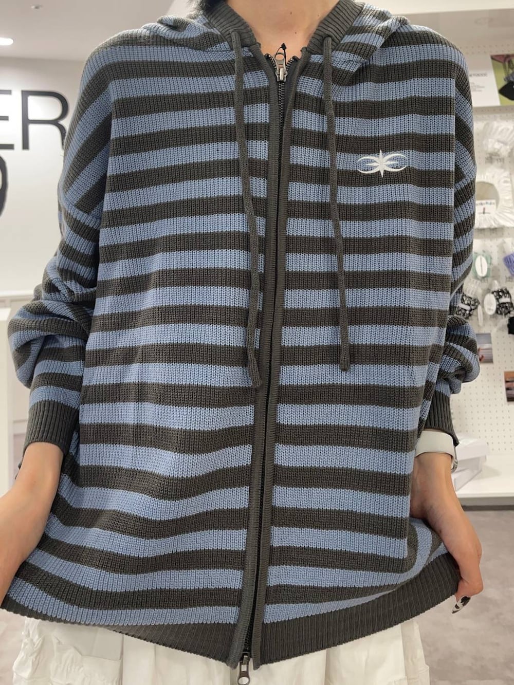 ブルー系のデニムパンツ、ブルー系のパーカー、ホワイト系のスカートを着用したレディースの夏コーディネートの7枚目の写真