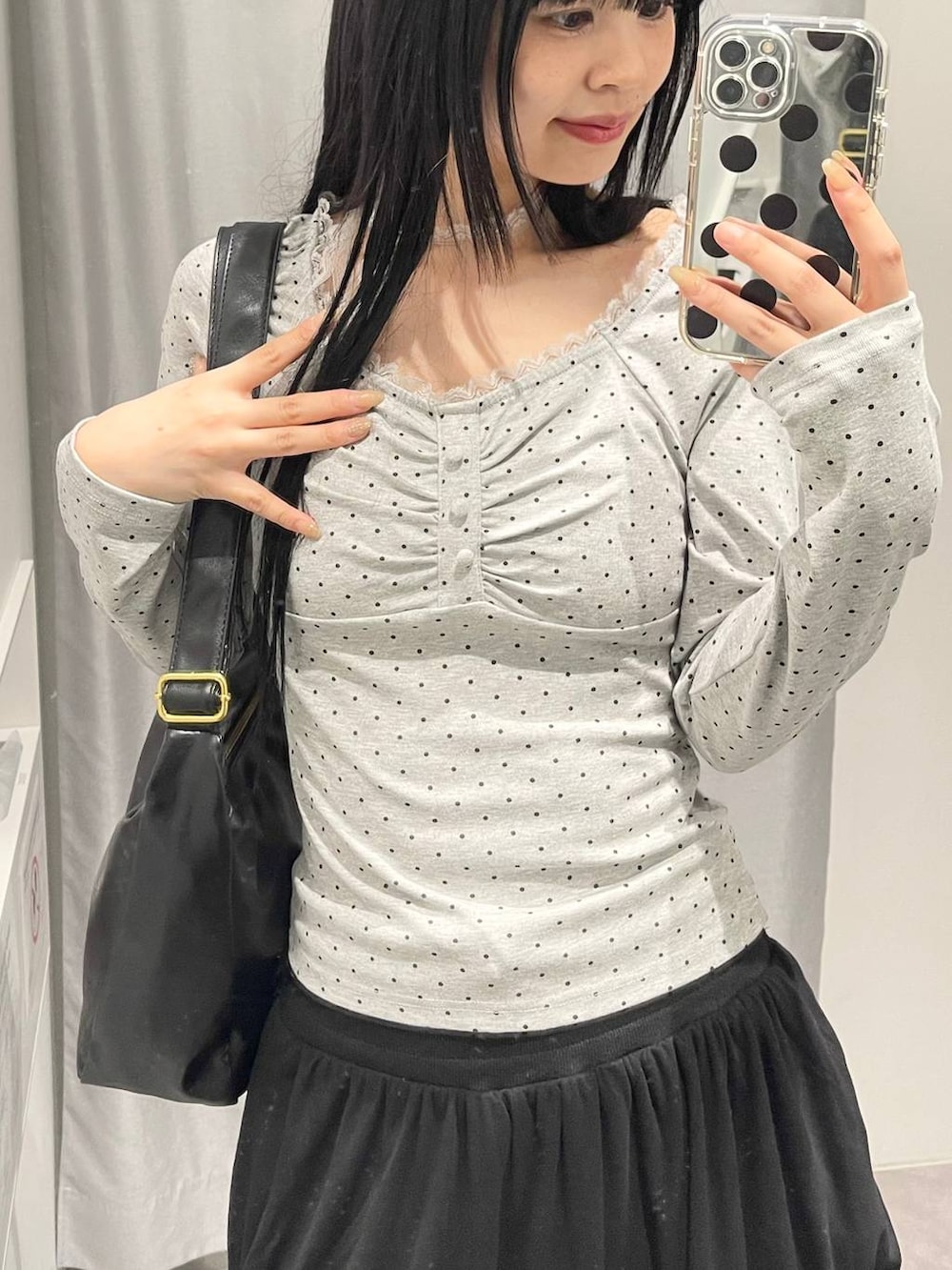 ブラック系のトートバッグ、ブラック系のスカート、グレー系のTシャツ/カットソーを着用したレディースの秋コーディネートの4枚目の写真