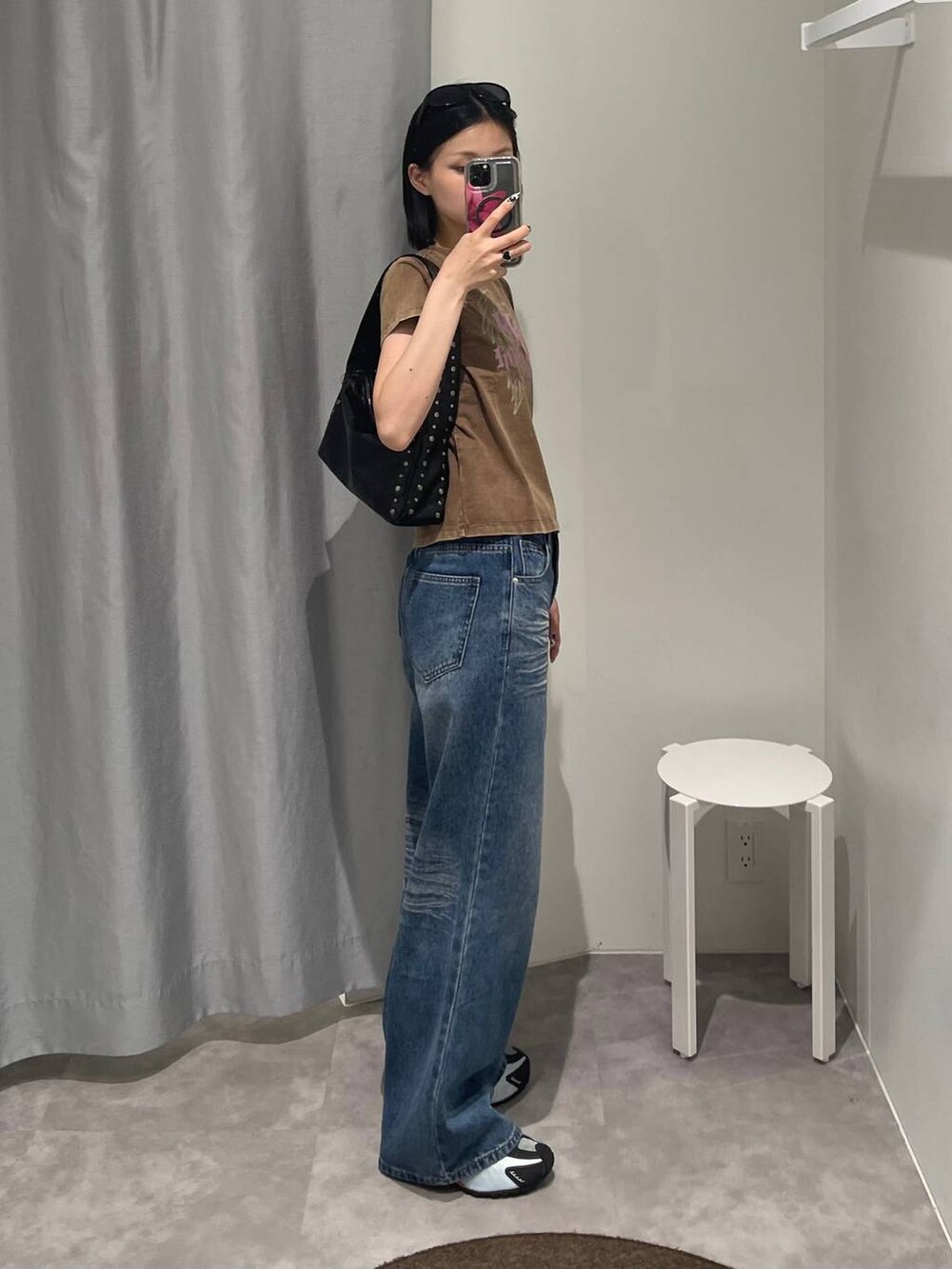 ブルー系のデニムパンツ、ブラック系のハンドバッグ、ブラック系のサングラスを着用したレディースの夏コーディネートの3枚目の写真