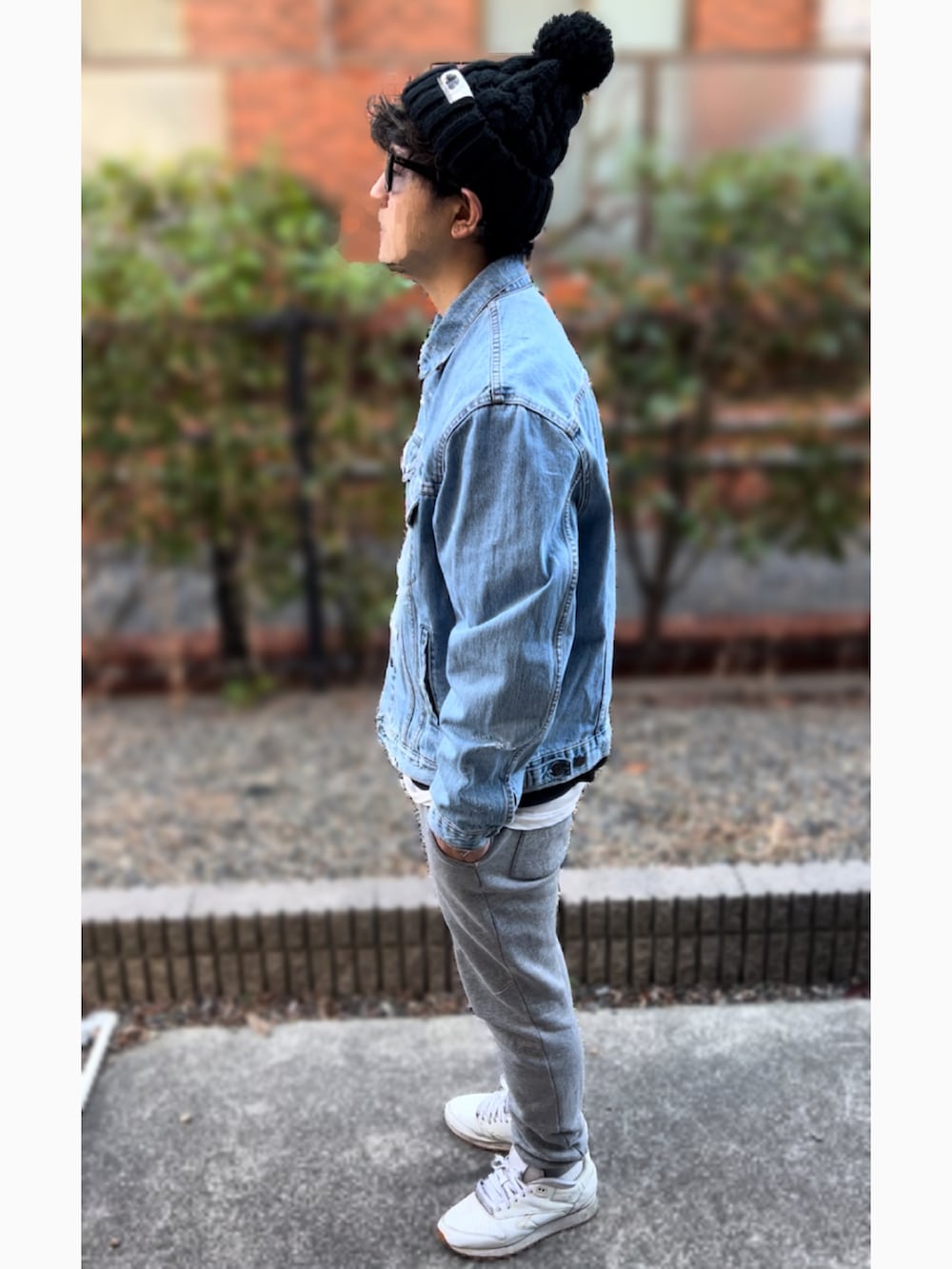 ブルー系のデニムジャケット、ホワイト系のスニーカー、ブルー系のサングラスを着用したメンズの冬コーディネートの2枚目の写真