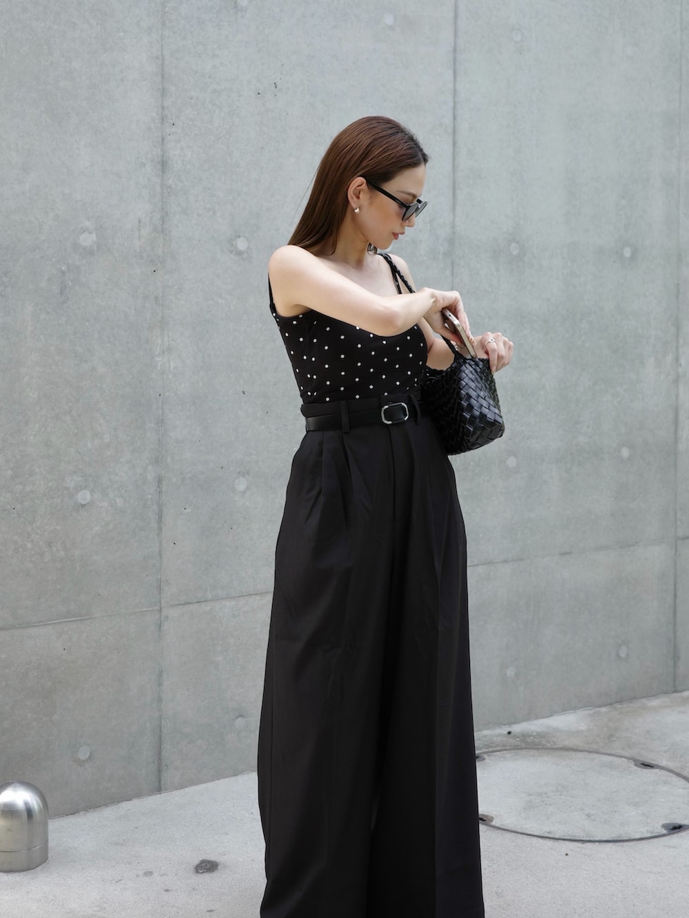 ブラック系のパンツ、ブラック系のキャミソール、ブラック系のサンダルを着用したレディースの夏コーディネートの2枚目の写真